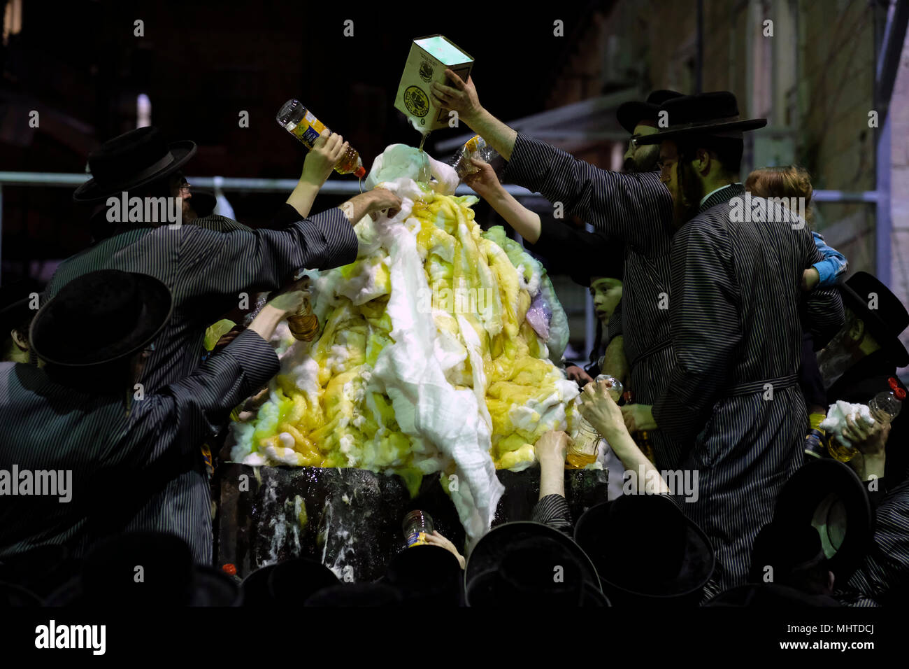 Les Juifs Haredi de Toldos Aharon Hassidic, dynastie purent l'huile dans un feu de joie dans le quartier religieux de Mea Shearim pendant la célébration des vacances de Lag BaOmer qui marque la célébration, interprétée par certains comme anniversaire de la mort du Rabbi Shimon bar Yochai, L'un des grands sages du judaïsme il y a 1800 ans et le jour où il a révélé les secrets les plus profonds de la kabbale un texte historique du mysticisme juif Banque D'Images
