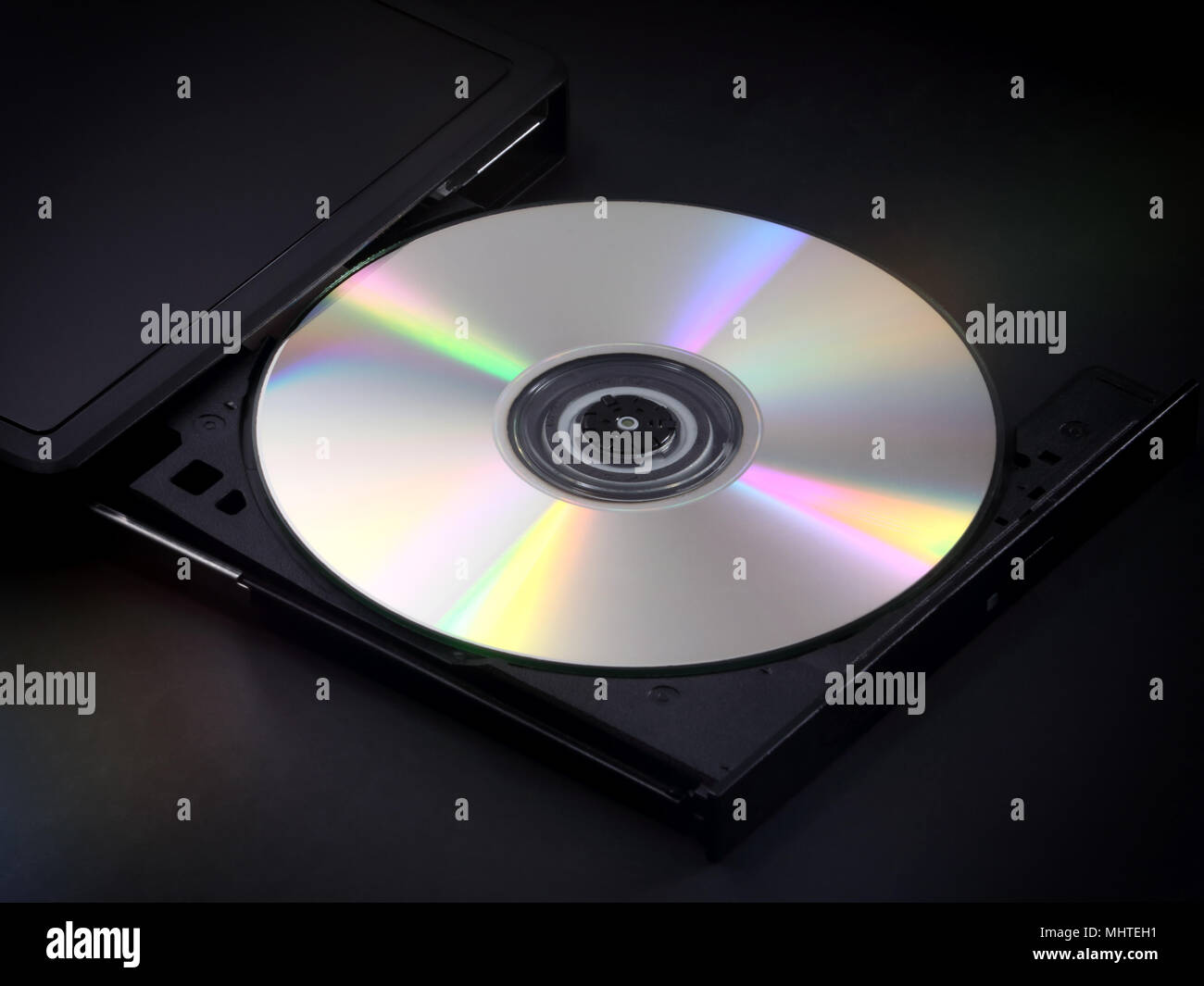 Une d'argent, brillant CD est illustré éjecté dans le bac d'un ordinateur de poche multimédia lecteur de disque. Banque D'Images