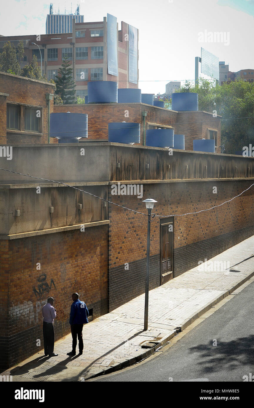 Deux hommes se lever et parler à un Street Quartier Central des Affaires de Johannesburg, Afrique du Sud. Banque D'Images