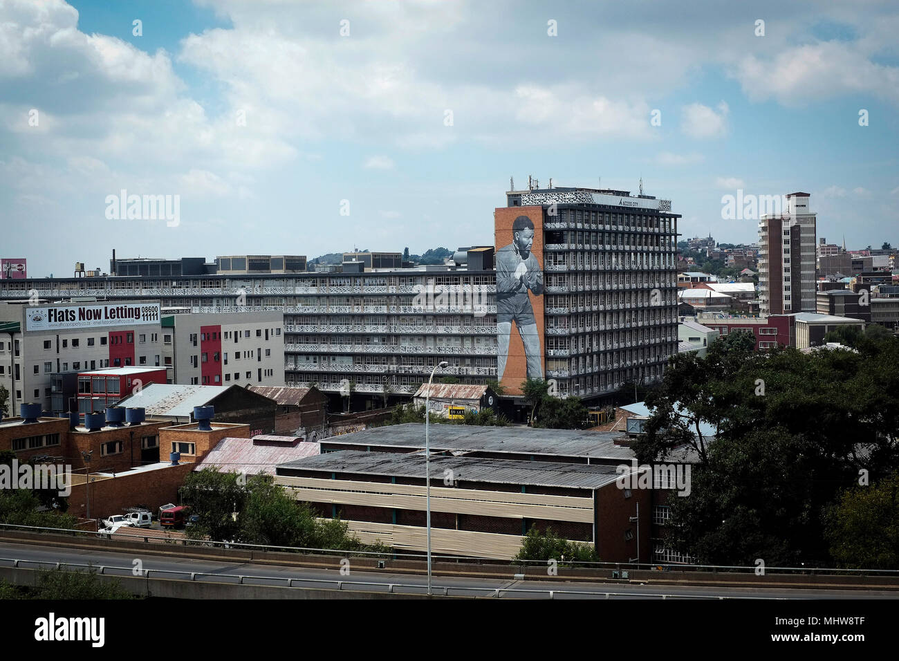 Vue d'un bâtiment dans le quartier central des affaires de Johannesburg, en Afrique du Sud avec une grande fresque de Nelson Mandela sur le mur extérieur. Banque D'Images