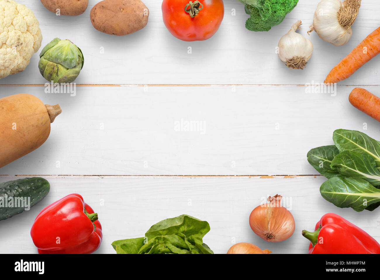 Des légumes sur un bureau en bois blanc. L'espace pour texte dans le milieu. Banque D'Images