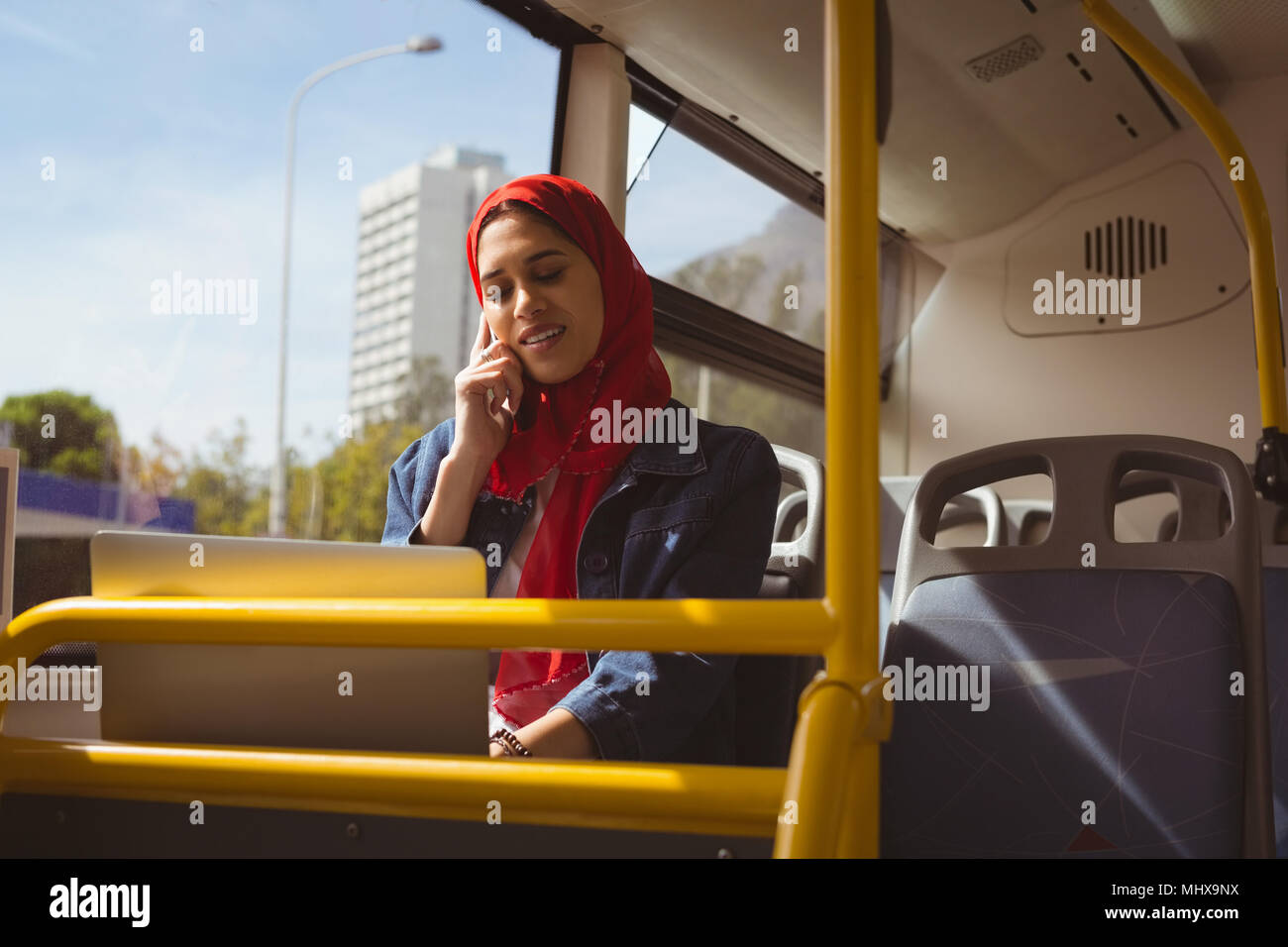 Hijab Woman talking on mobile phone dans le bus Banque D'Images