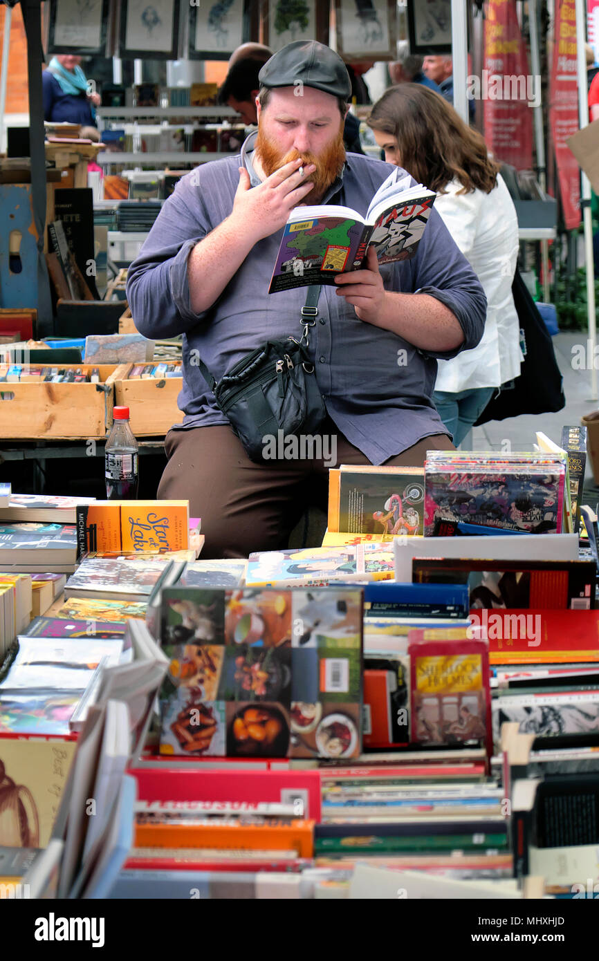 Un vendeur de livre de fumer au marché du livre de Temple Bar, Temple Bar Square, Dublin, Irlande Banque D'Images