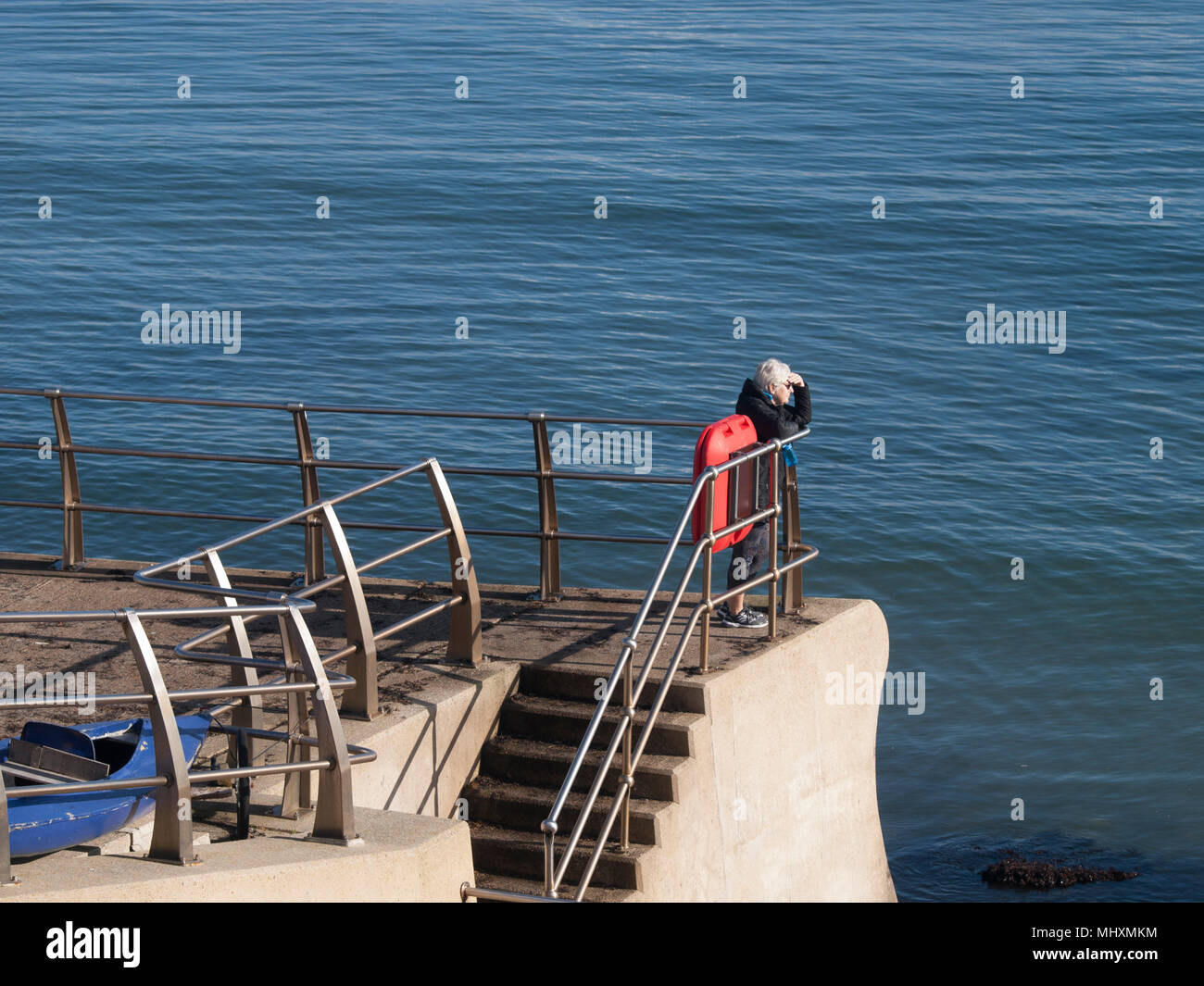 Une femme à la retraite à la recherche dans la mer. Banque D'Images
