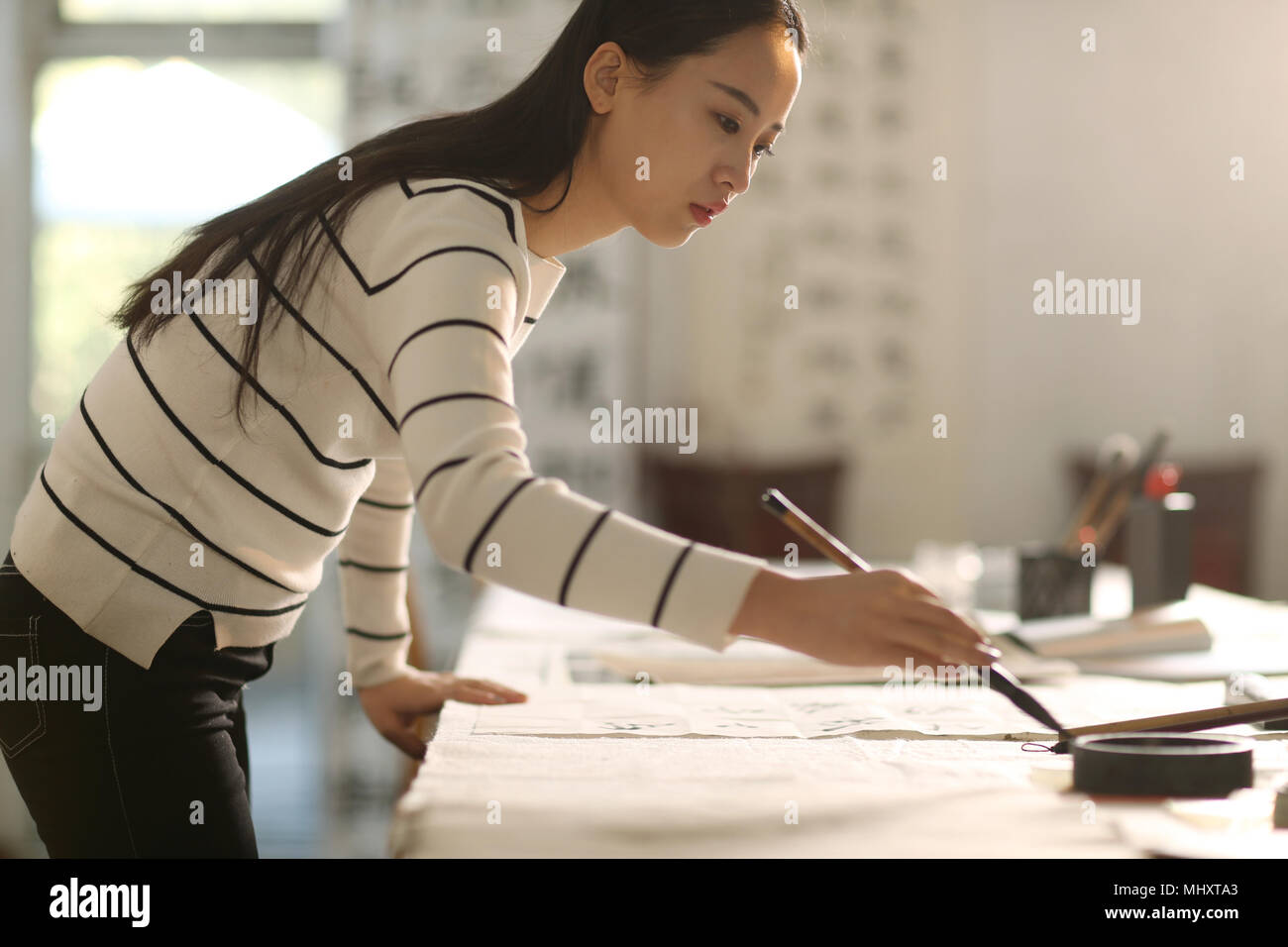 Les jeunes femmes d'apprendre la calligraphie Banque D'Images