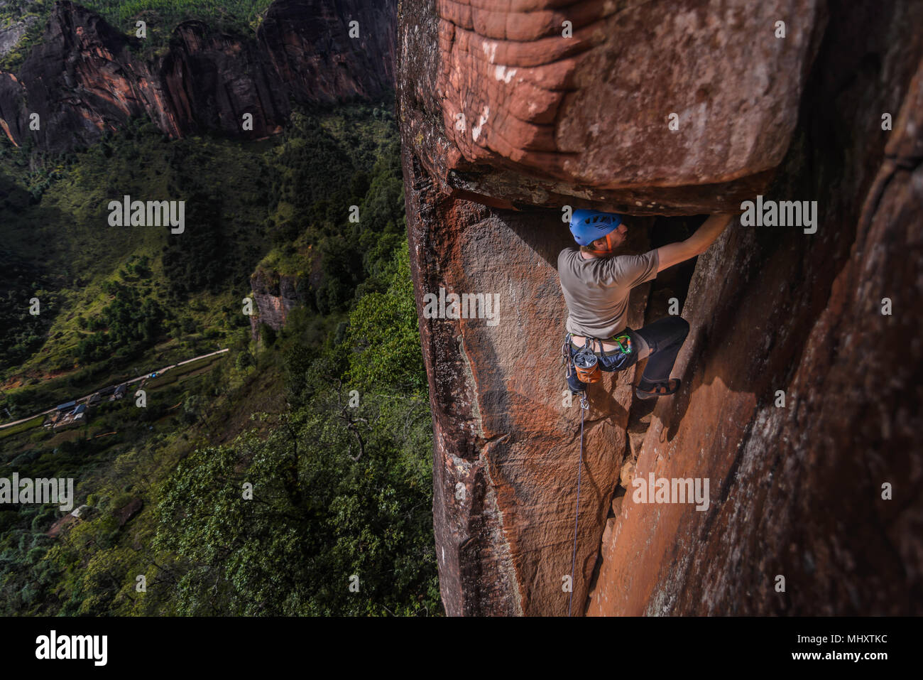 Rock climber climbing rock grès, elevated view, le chaulage, Province du Yunnan, Chine Banque D'Images