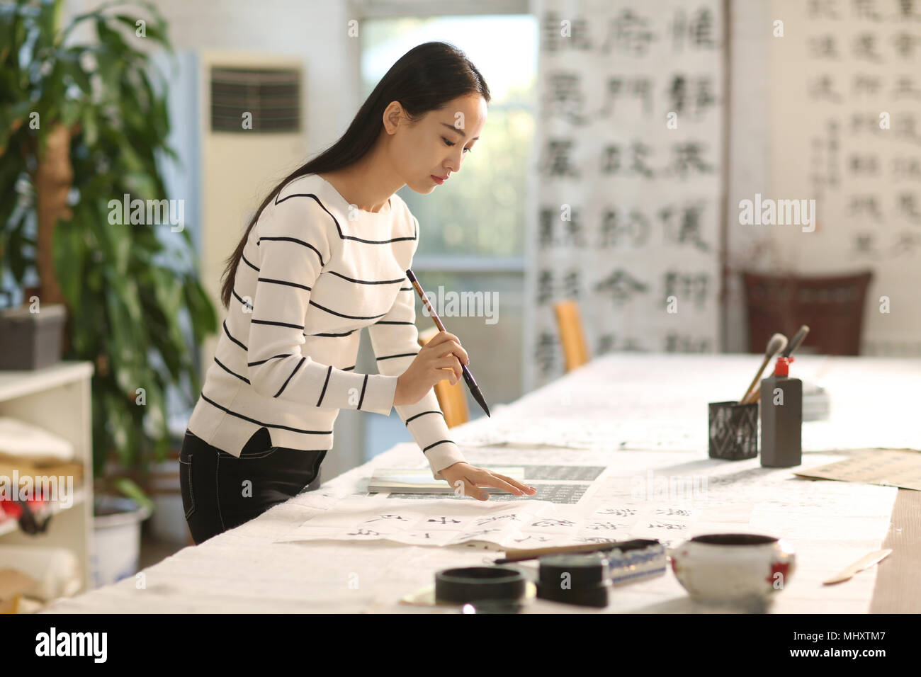 Les jeunes femmes d'apprendre la calligraphie Banque D'Images