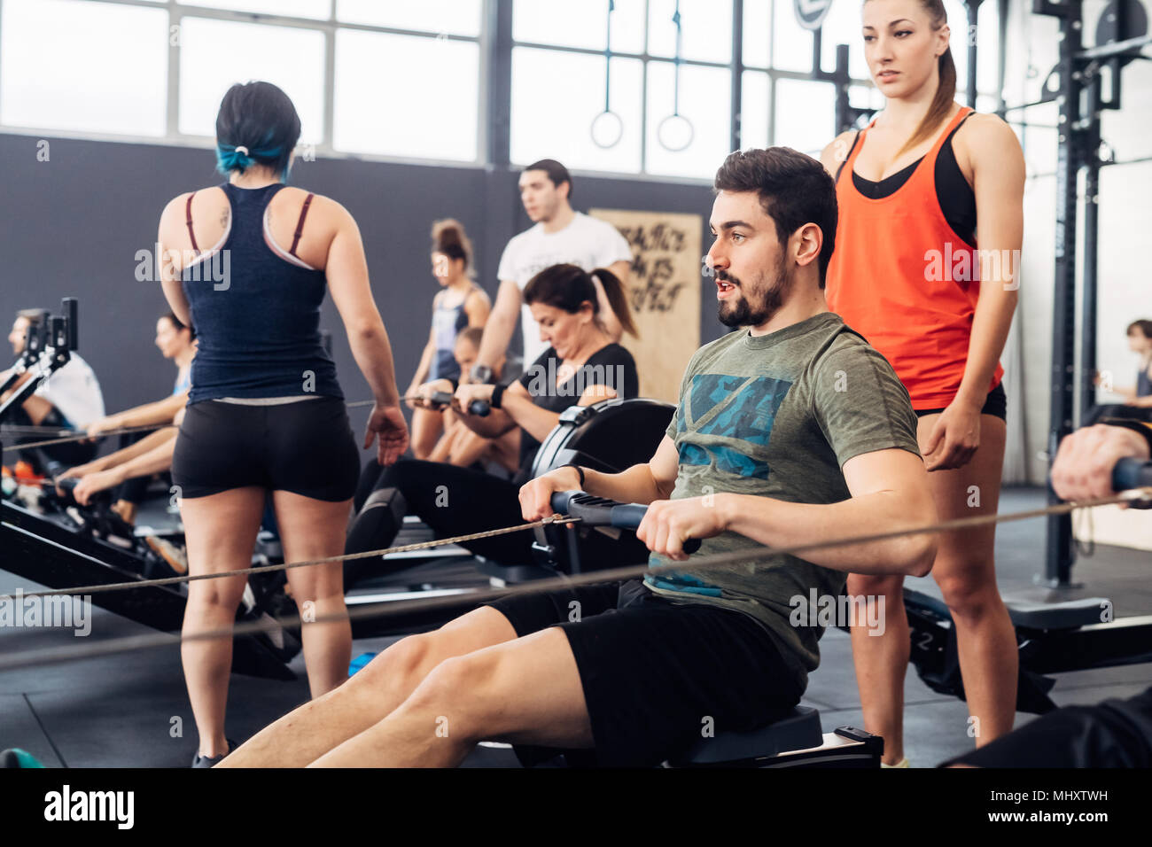 Man using rowing machine in gym Banque D'Images