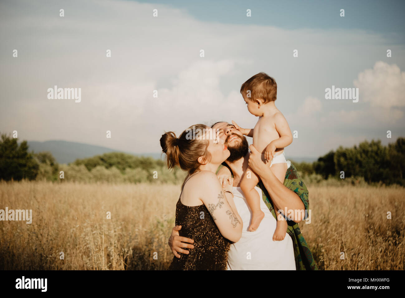 Couple avec bébé fille sur golden grass field, Arezzo, Toscane, Italie Banque D'Images