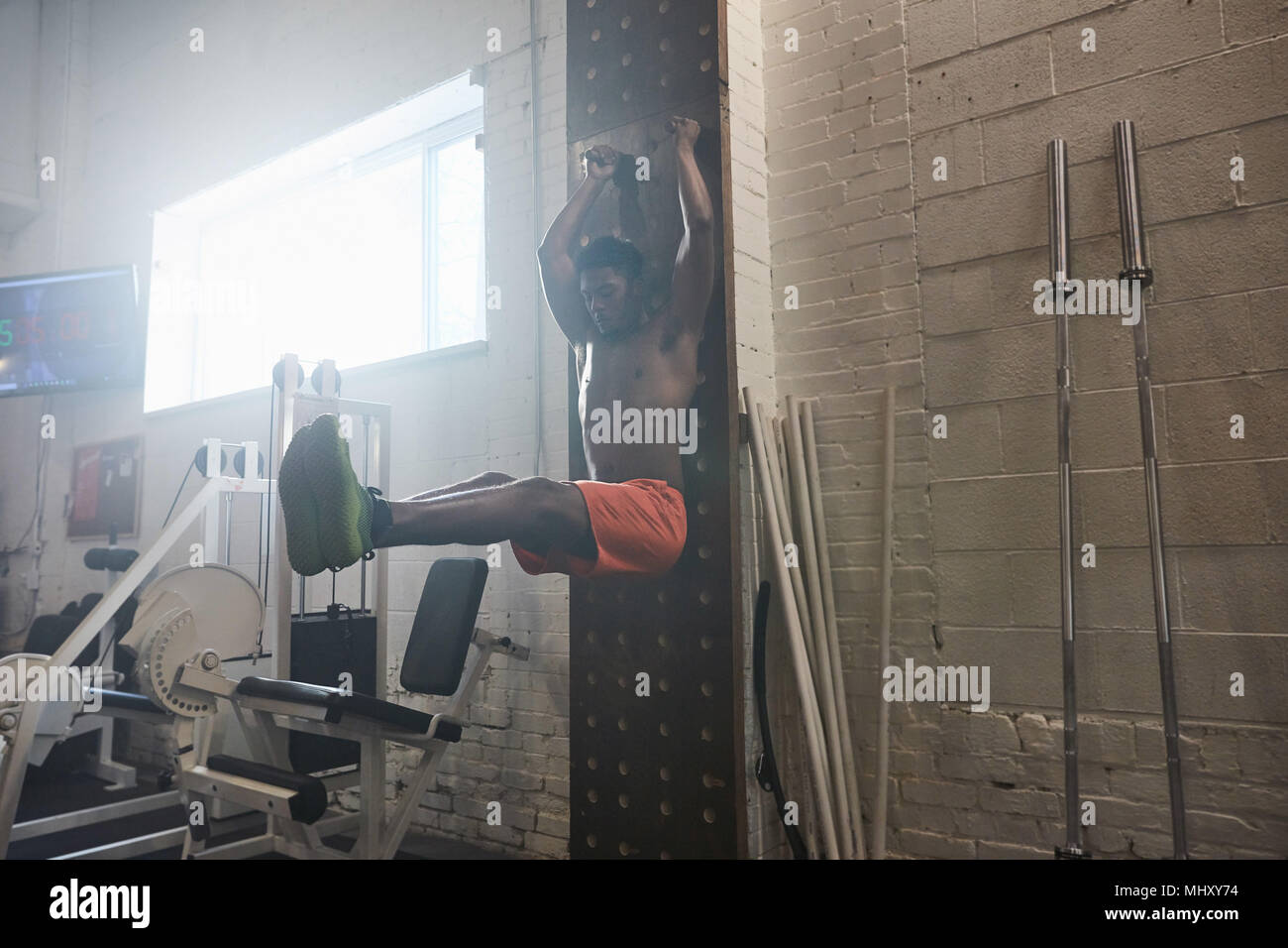 L'homme à l'aide de sport l'équipement d'exercice, faisant tirer la jambe ups Banque D'Images L'homme à l'aide de sport l'équipement d'exercice, faisant tirer la jambe ups Banque D'Images