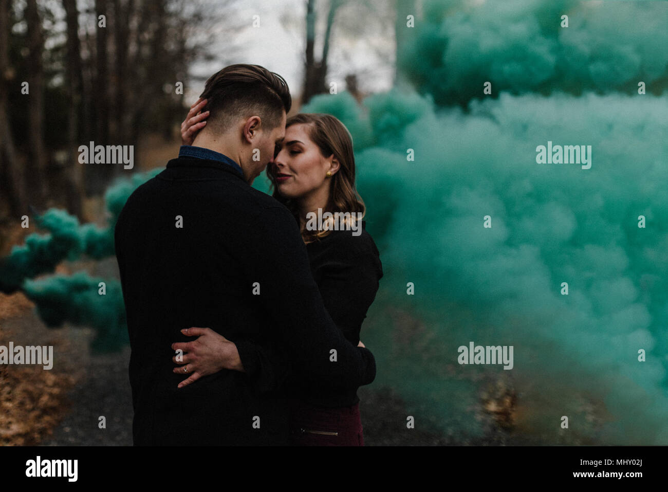 Couple en forêt par nuage de fumée verte Banque D'Images