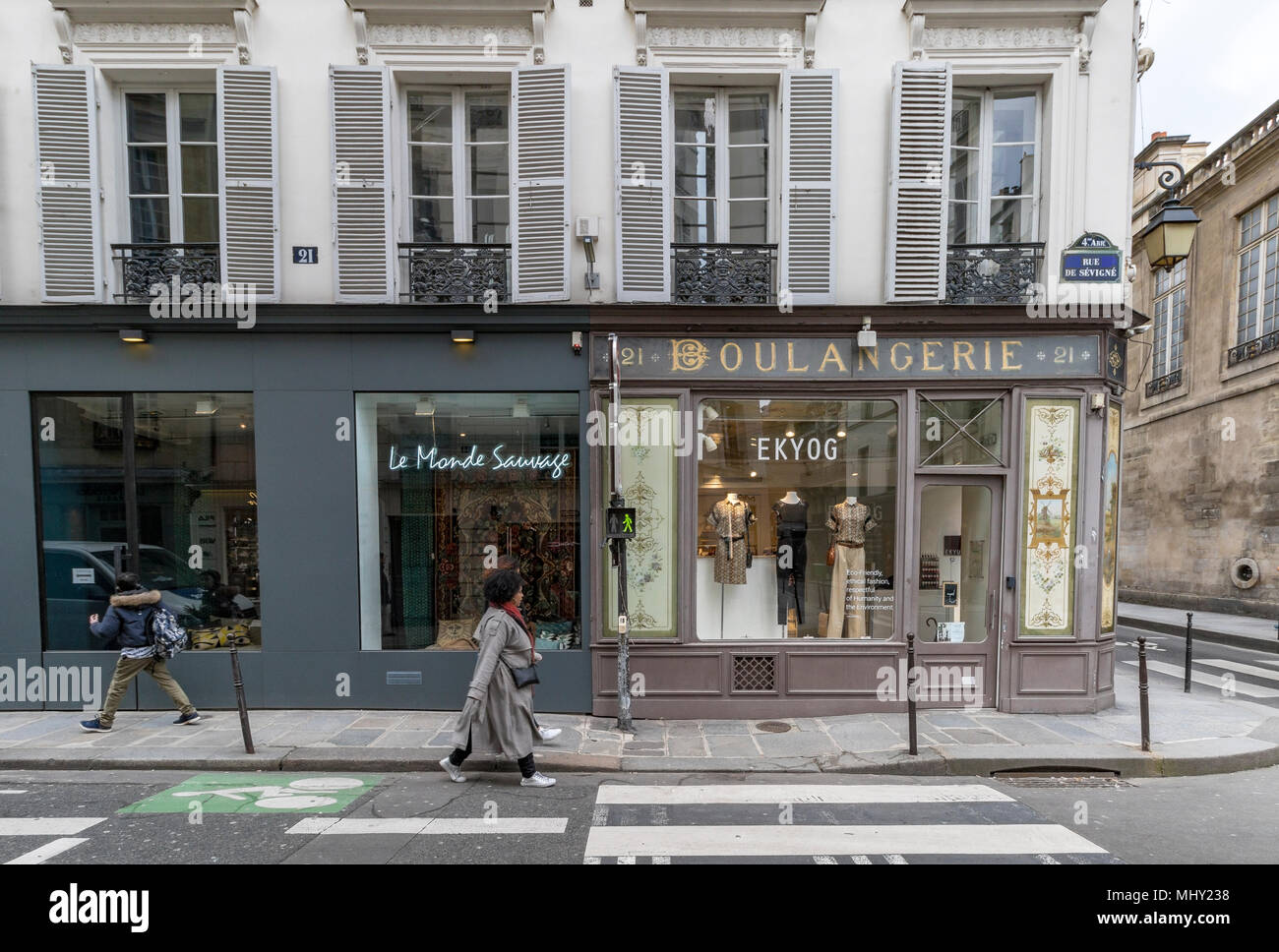 Une femme marche dernières Ekyog, une ancienne boulangerie transformée en un magasin de vêtements de la rue de Sévigné, Le Marais, Paris, France Banque D'Images