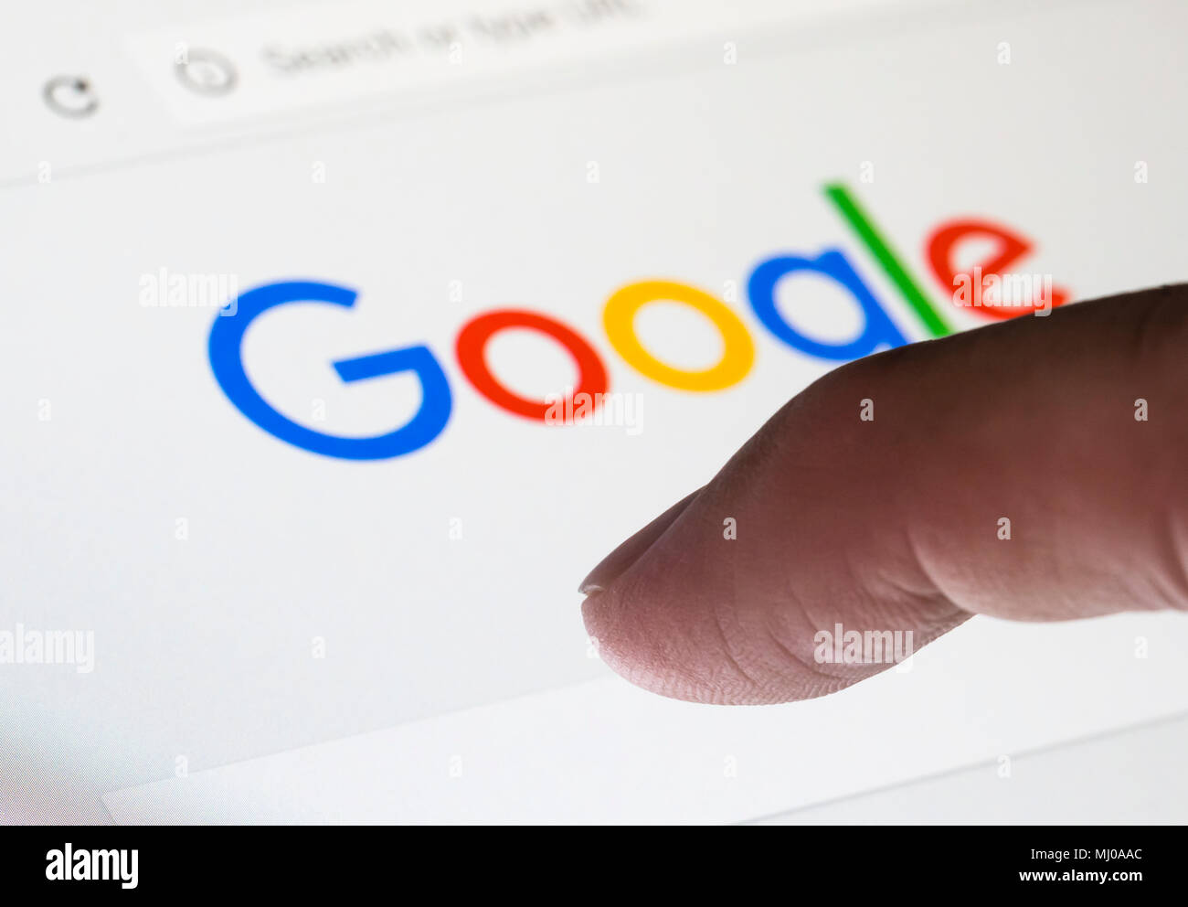 À propos de doigt pour taper une recherche sur le moteur de recherche Google Internet site web. Banque D'Images