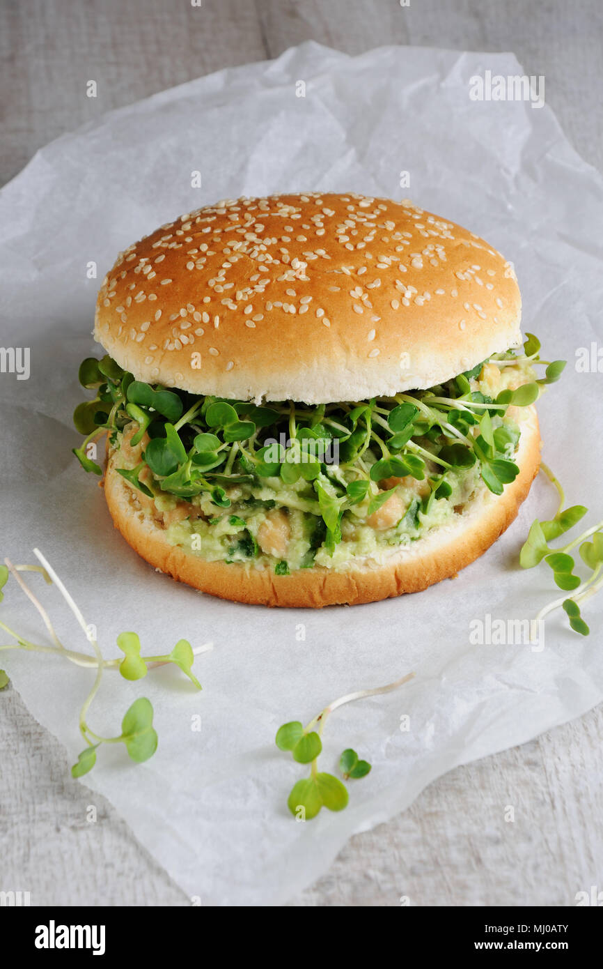 Un burger végétarien fait à partir d'un pain sans gluten avec les pois chiches, d'avocat et d'herbes, pousses de radis. Un dîner santé et rapide idée que vous vous sentez energi Banque D'Images