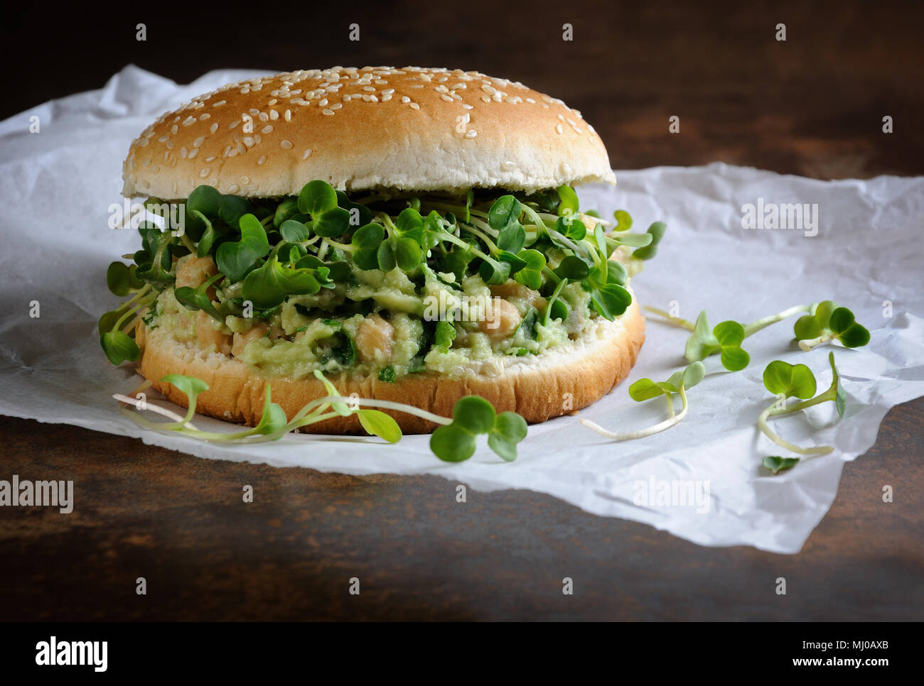 Un burger végétarien fait à partir d'un pain sans gluten avec les pois chiches, d'avocat et d'herbes, pousses de radis. Un dîner santé et rapide idée que vous vous sentez energi Banque D'Images