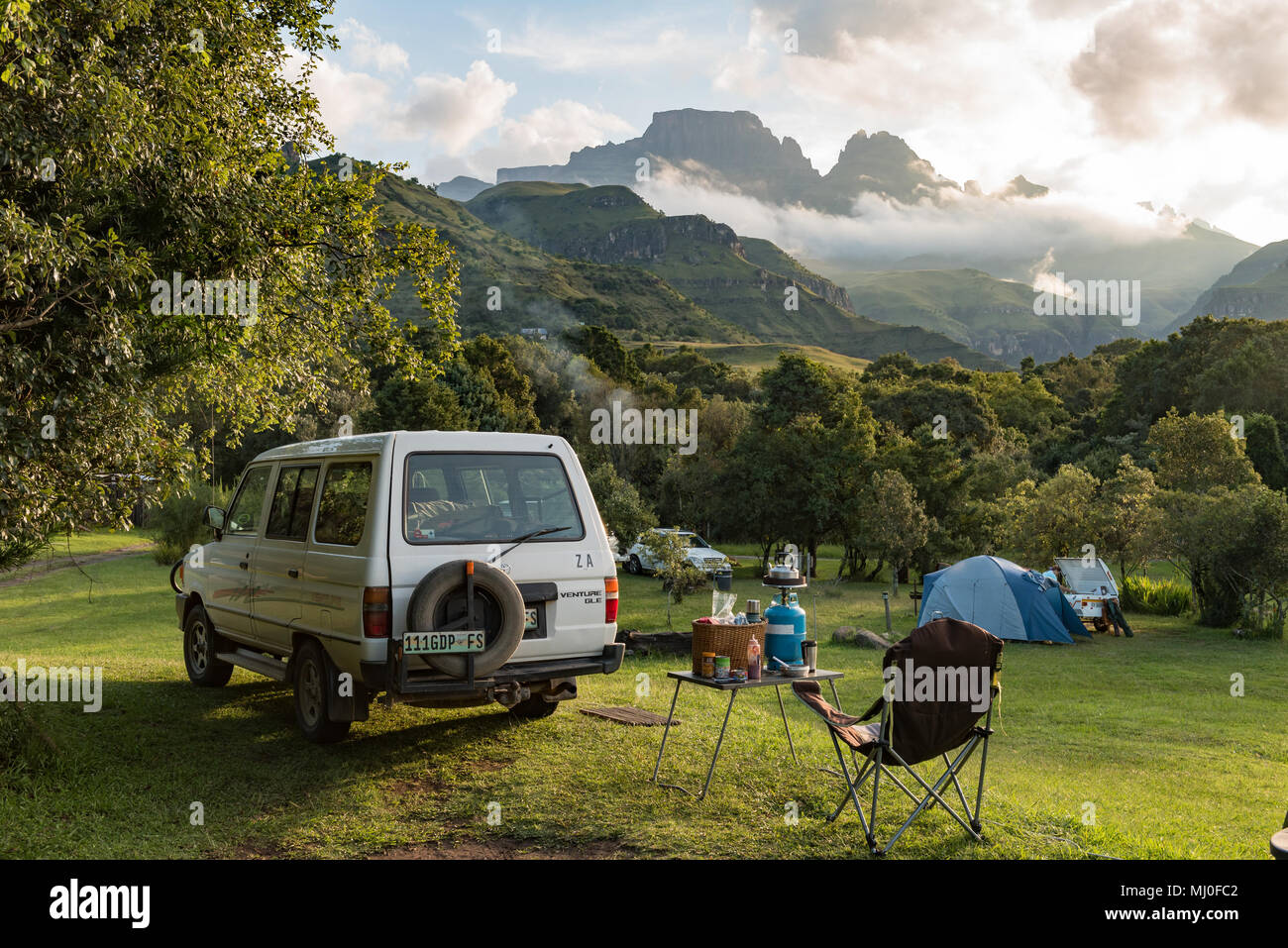 MONKS COWL, AFRIQUE DU SUD - le 18 mars 2018 : une tente et des véhicules sur le camping au bord de moines dans le Drakensberg. Cathedral Peak (à gauche) et Des Moines C Banque D'Images