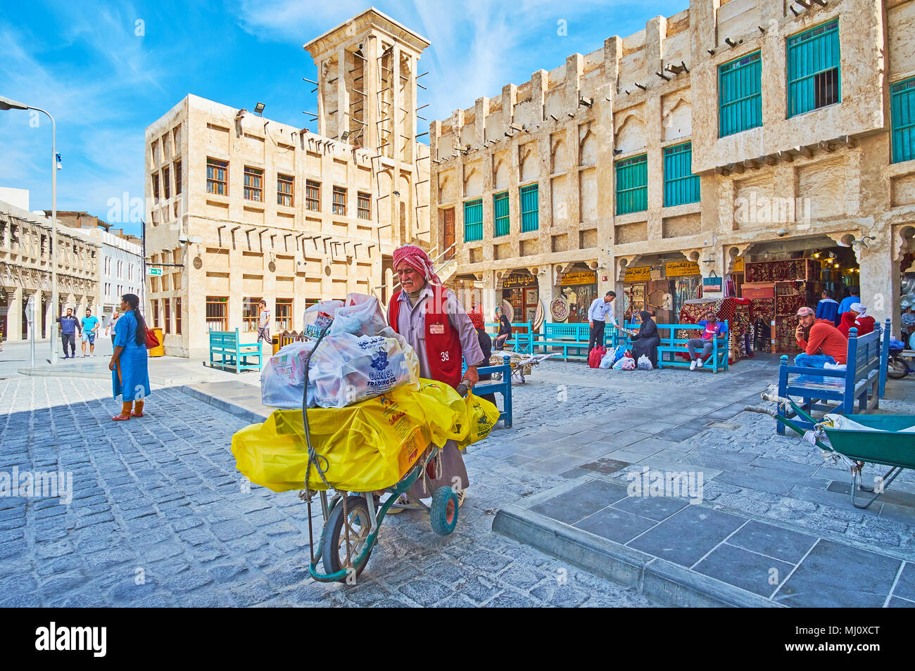 DOHA, QATAR - 13 février 2018 : Les officiers de porter au travail, transportant des marchandises dans la région de Old street brouette de Souq Waqif, le 13 février à Doha Banque D'Images