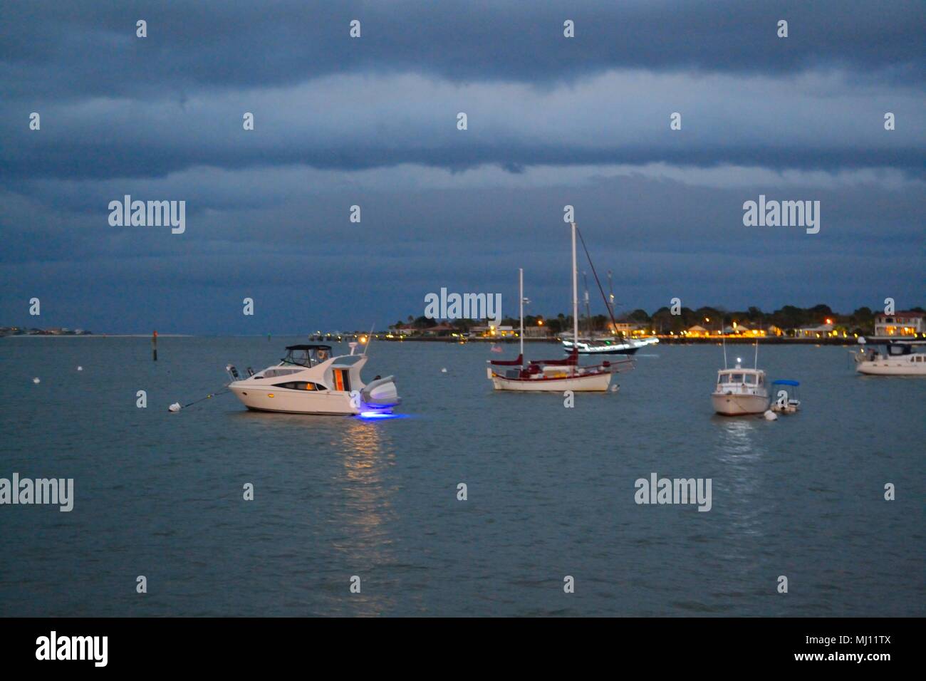 Bateaux éclairés sur la baie au crépuscule Banque D'Images