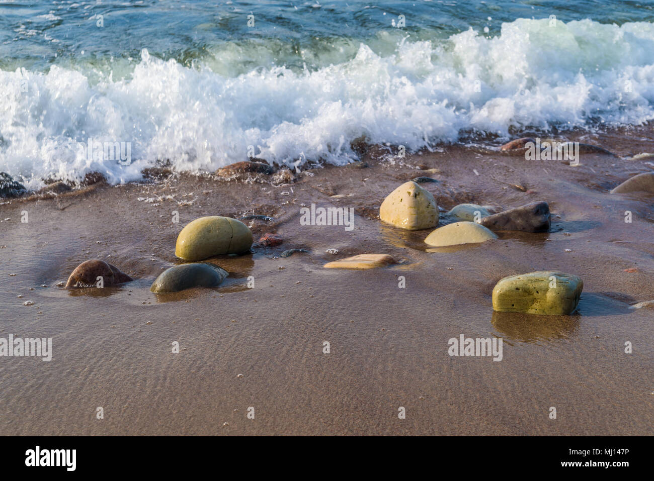 La réserve naturelle de l'est de la côte de Boda sur Oland, Sweden. Rochers humides poli naturellement sur une plage de sable. Banque D'Images