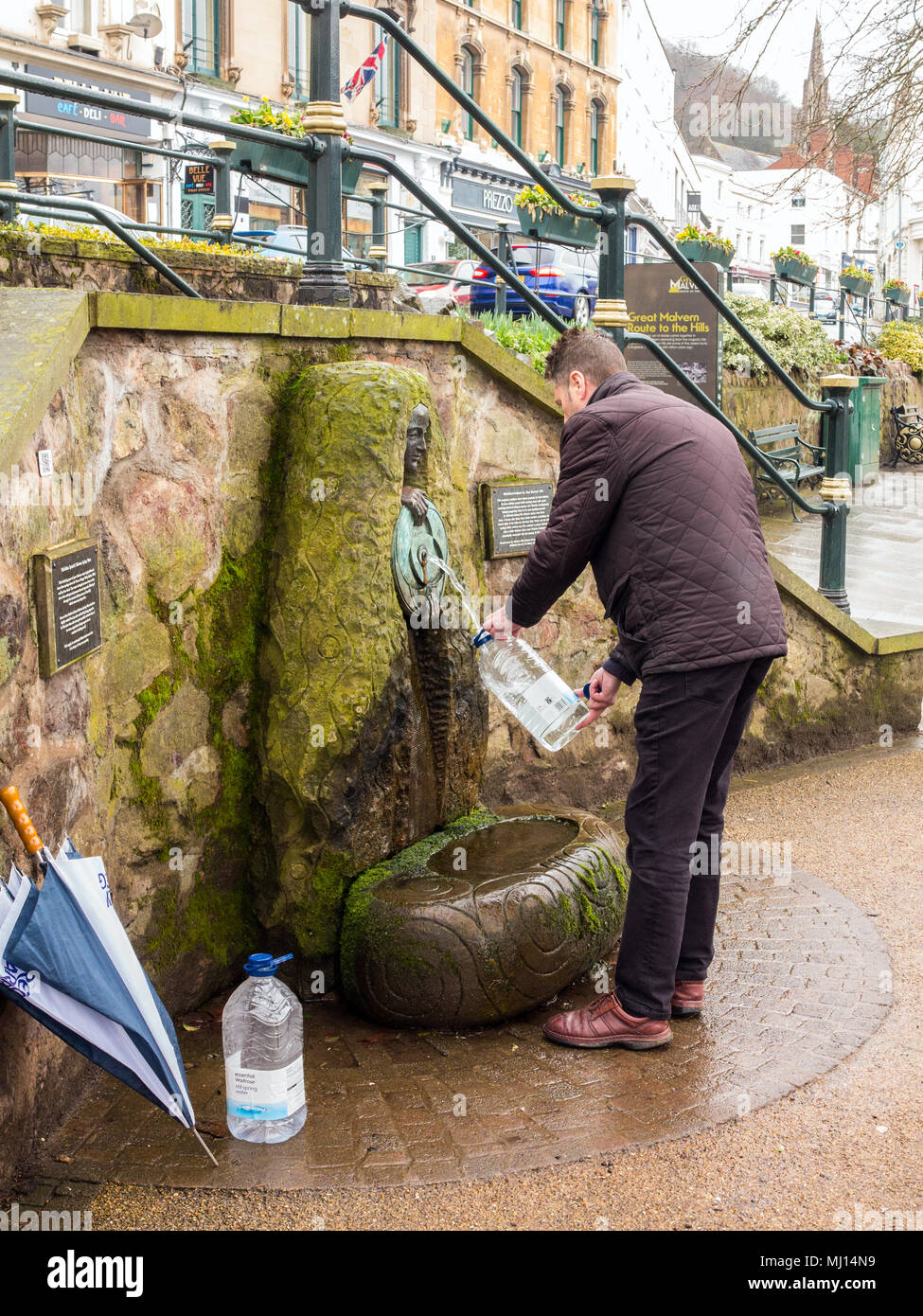 Man filling une bouteille avec l'eau de source naturelle à la pression dans le centre-ville de Great Malvern Royaume-uni Angleterre Worcester Banque D'Images