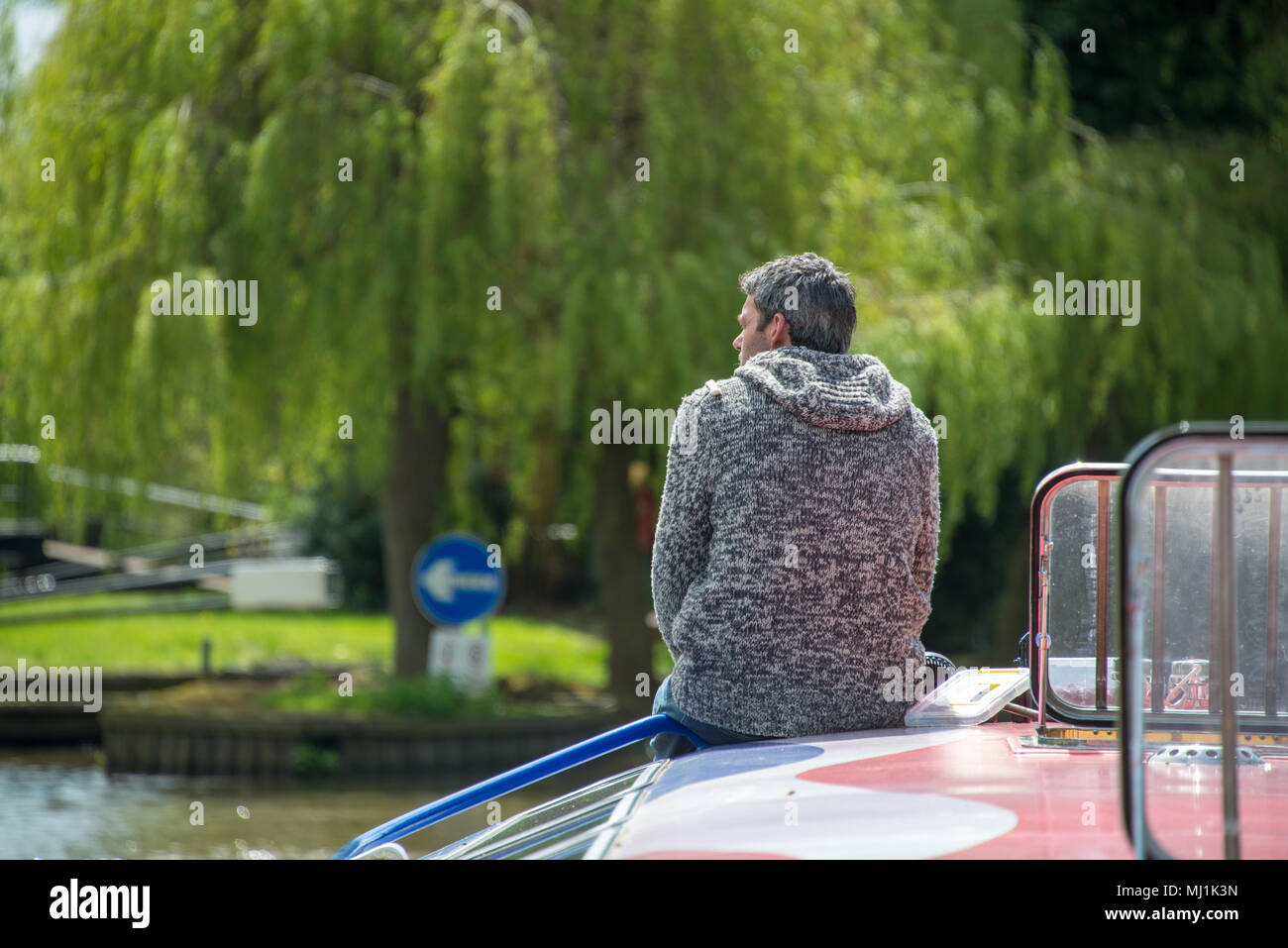 Homme s'assit sur la retraite de l'arc porte bateau Cavalier gris avec des cheveux gris en contemplant la magnifique saule sur la rivière Avon en Grande-Bretagne Banque D'Images