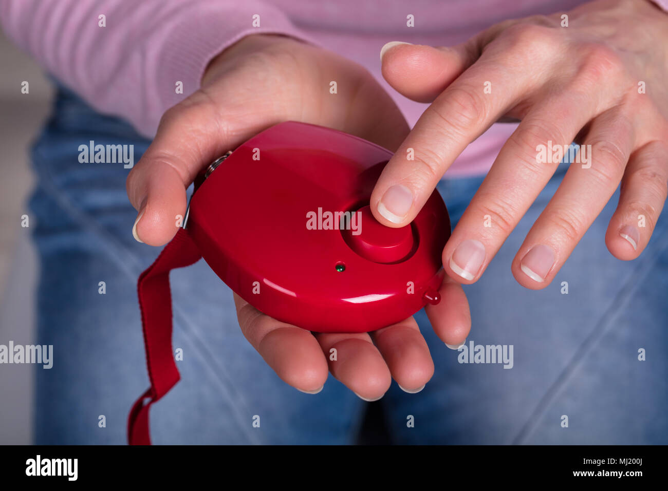 Close-up of Woman's Hand en appuyant sur le bouton d'alarme personnelle Banque D'Images