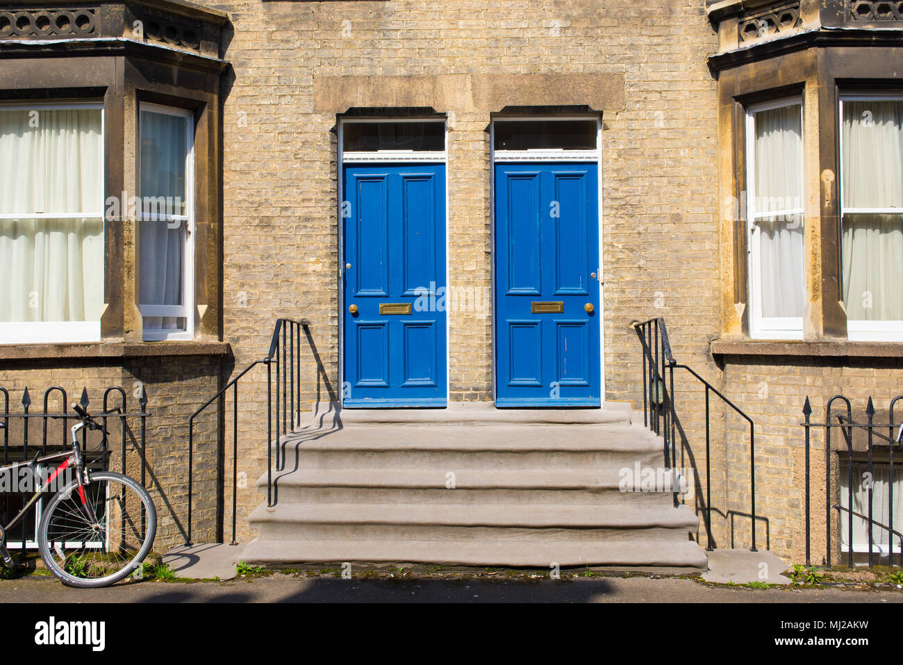 Deux portes en bois bleu identique à l'entrée d'une maison de style britannique classique de style Victorien Banque D'Images