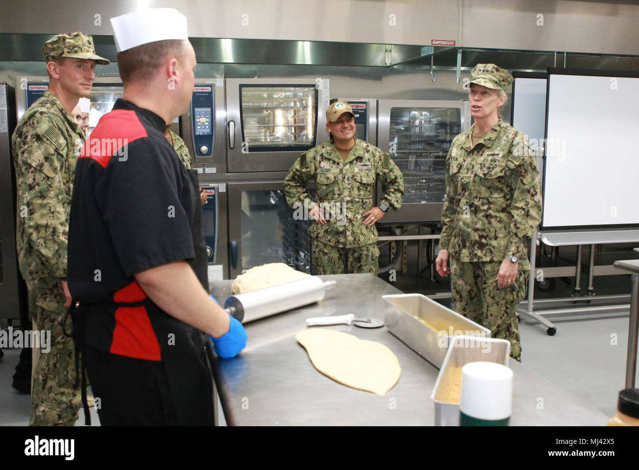 SAN DIEGO (Mar. 22, 2018) - Les installations de la Marine, commandant de Commandement (CNIC) Vice-amiral. Mary Jackson (à droite) demande à un spécialiste culinaire affecté à la base navale de San Diego (NBSD) à propos de la cannelle qu'il fait dans la boulangerie. L'NBSD Mercer Hall Cuisine, qui sert des milliers de marins par jour, récemment modernisé son Bake shop. Jackson est une tournée des installations dans la région du Sud-Ouest, d'évaluer et de fournir des commentaires sur la façon dont les bases peuvent mieux servir du combattant et de la flotte. Les installations de la marine sont complexes, diverses plates-formes conçues pour soutenir et améliorer la disponibilité opérationnelle en fournissant l'homme combattant Banque D'Images