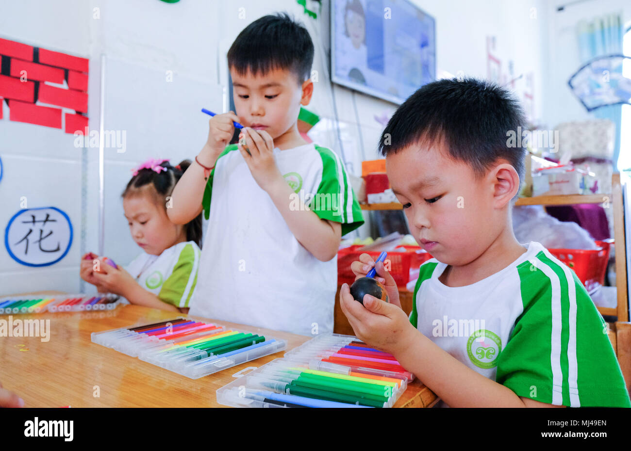 Changxing, Changxing County de la Chine de l'est la province de Zhejiang. 4 mai, 2018. Les enfants de la peinture sur les oeufs de participer à un concours à venir frapper le marquage 'Lixia', ou au début de l'été, à une garderie dans Lijiaxiang Township, comté de Changxing est de la Chine, la province du Zhejiang, le 4 mai 2018. 'Lixia' marque le septième terme solaire sur le calendrier lunaire chinois. C'est une coutume folklorique pour les populations locales d'accueillir 'Lixia', qui tombe le 5 mai cette année. Credit : Xu Yu/Xinhua/Alamy Live News Banque D'Images