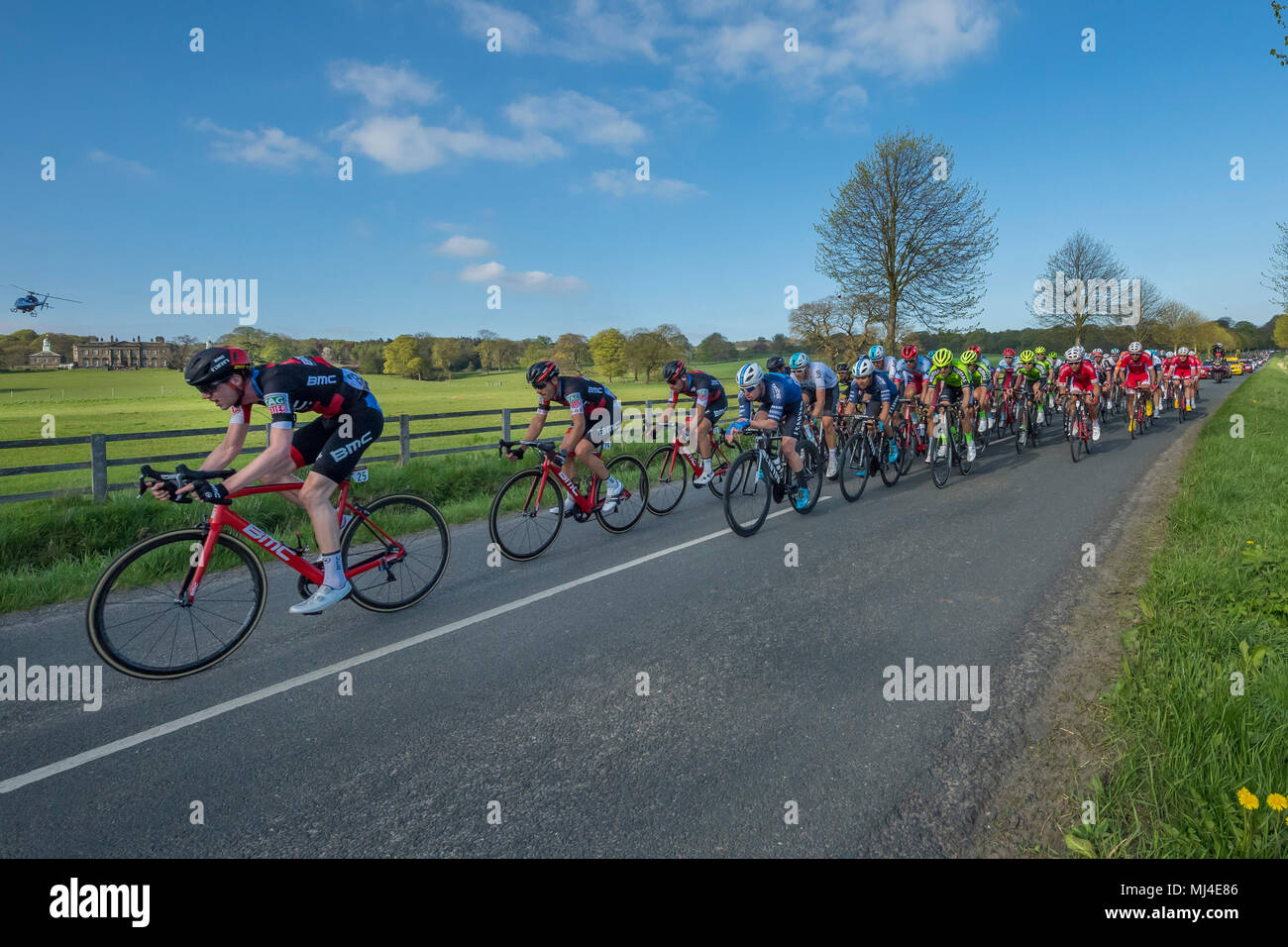 Denton, West Yorkshire, 4 mai 2018. Grand groupe de cyclistes masculins dans le pelaton concurrentes, dans l'ensoleillée Tour de Yorkshire, 2018 sont de course passé Denton, tout droit, plat, scenic, campagne lane près de Ilkley, North Yorkshire, Angleterre, Royaume-Uni. Crédit : Ian Lamond/Alamy Live News Banque D'Images