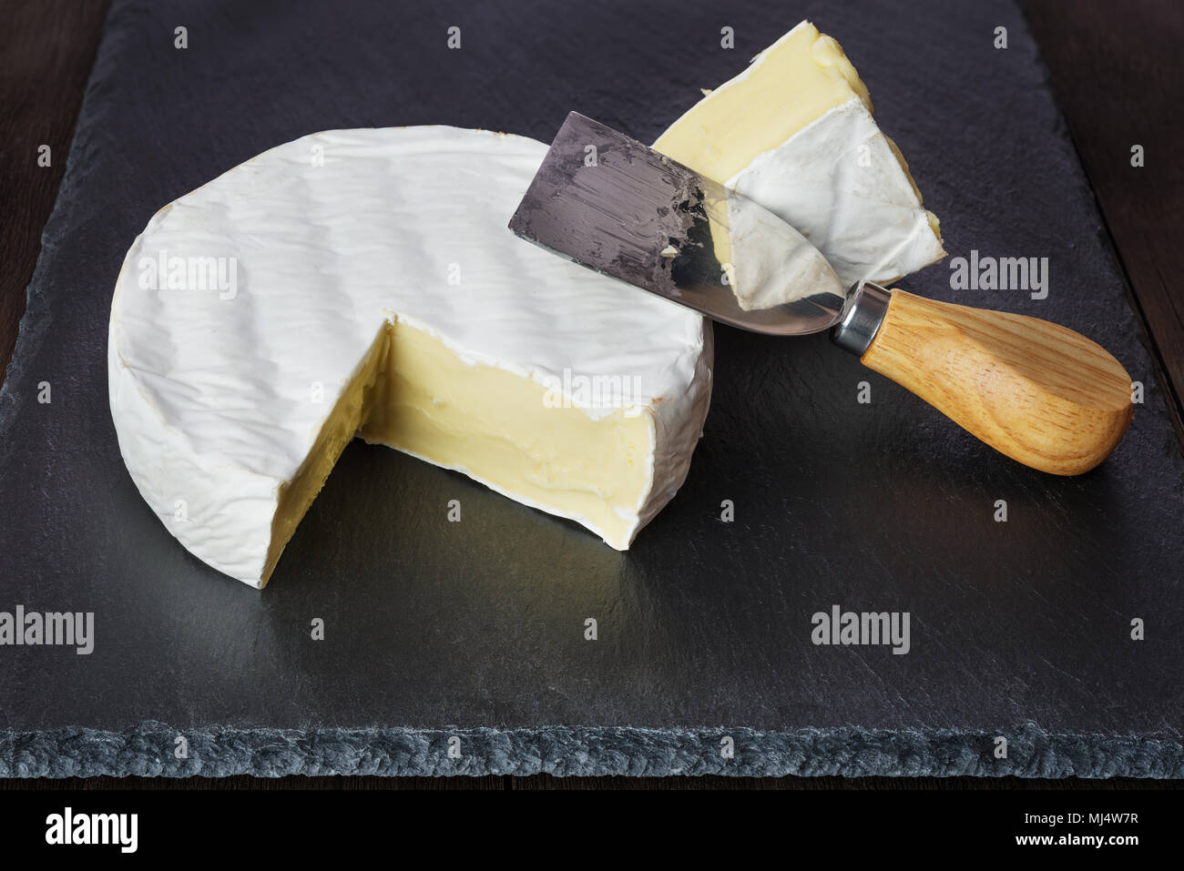 Fromage frais et fromage Couteau sur une plaque d'ardoise noire Banque D'Images
