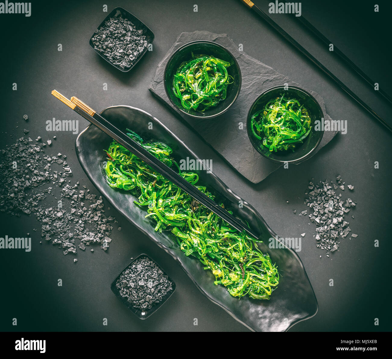 Salade d'algues japonaises avec sel noir sur fond noir Banque D'Images