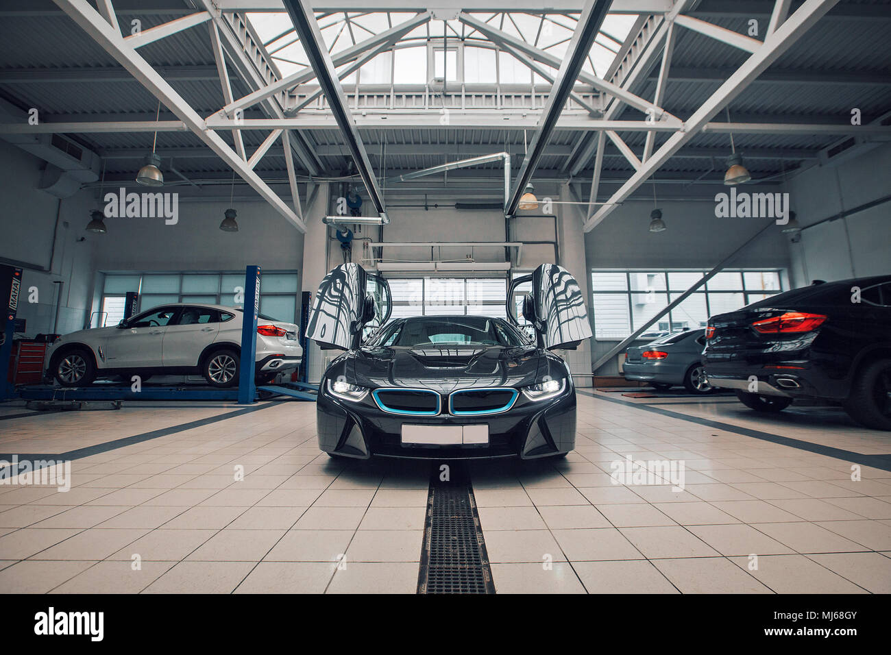 Une voiture à la mode d'une classe d'élite est dans la voiture, les portes s'ouvrir. Autour du soleil brille, publicité service de voiture. Banque D'Images