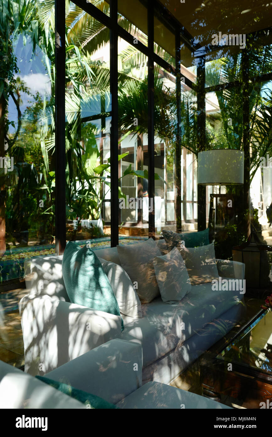 Chaises et table en piscine contre des arbres vu à travers la vitre Banque D'Images