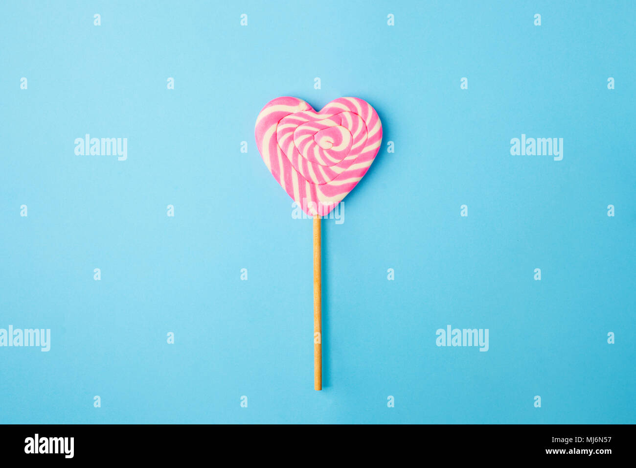 Un coeur en spirale rose et blanc sur fond bleu de sucette, télévision lay concept minimal, à la mode style pop art, isolé photo Banque D'Images
