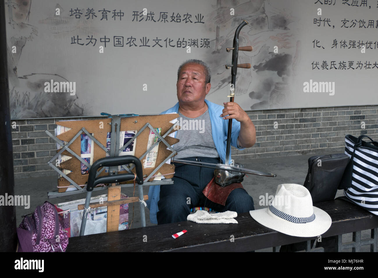 Vieille homme jouant de la musique traditionnelle de Tianshui, Gansu, Chine, l'Asie, à l'aide d'instrument avec musican les chaînes. Les personnes âgées, la tradition, la culture, Banque D'Images