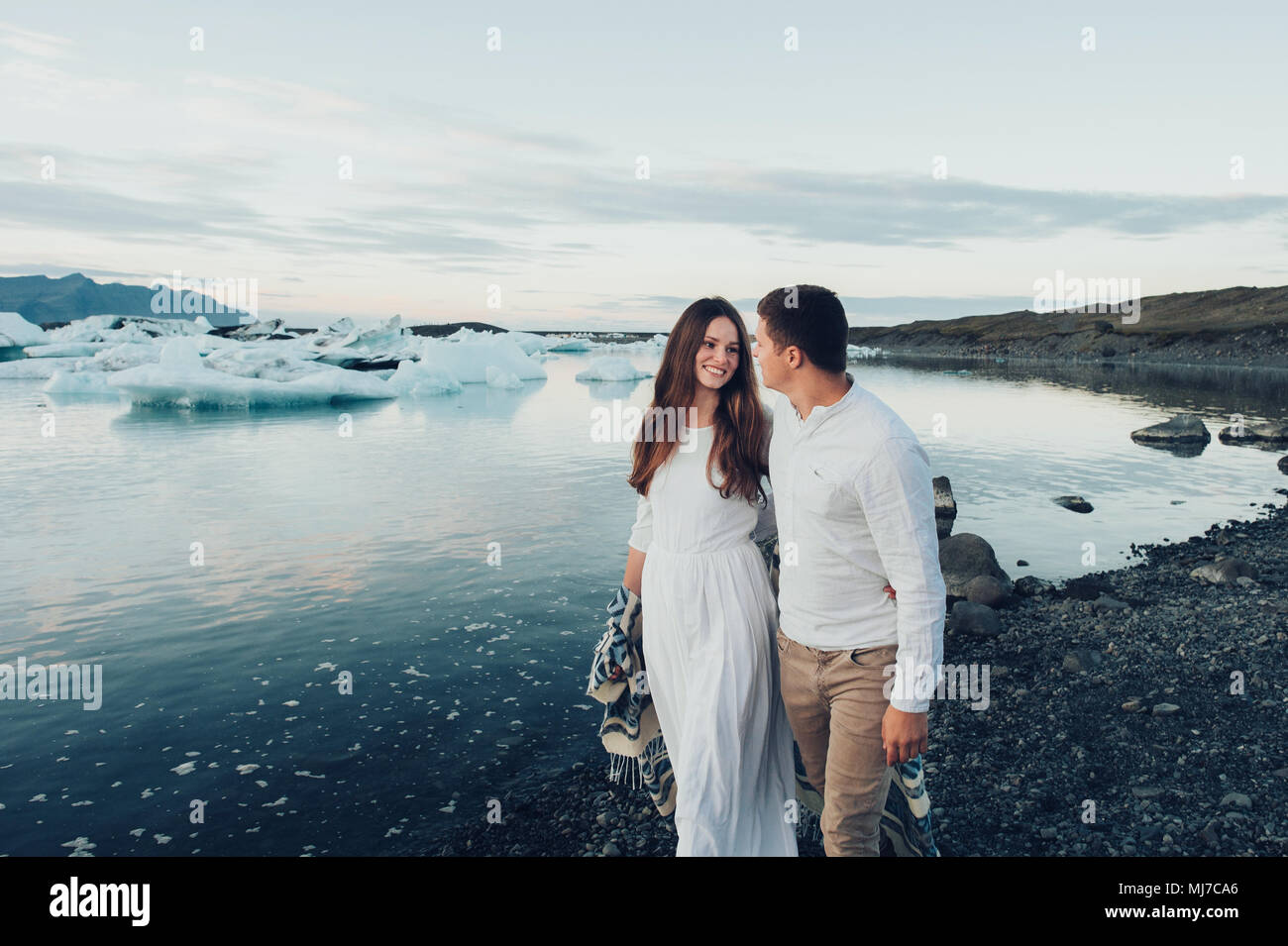 Jeune couple élégant dans l'amour de l'Islande. La femme et l'homme embrasser et veulent baiser les uns les autres. Quel beau couple kissing in lagoon Glacier en Islande. Banque D'Images