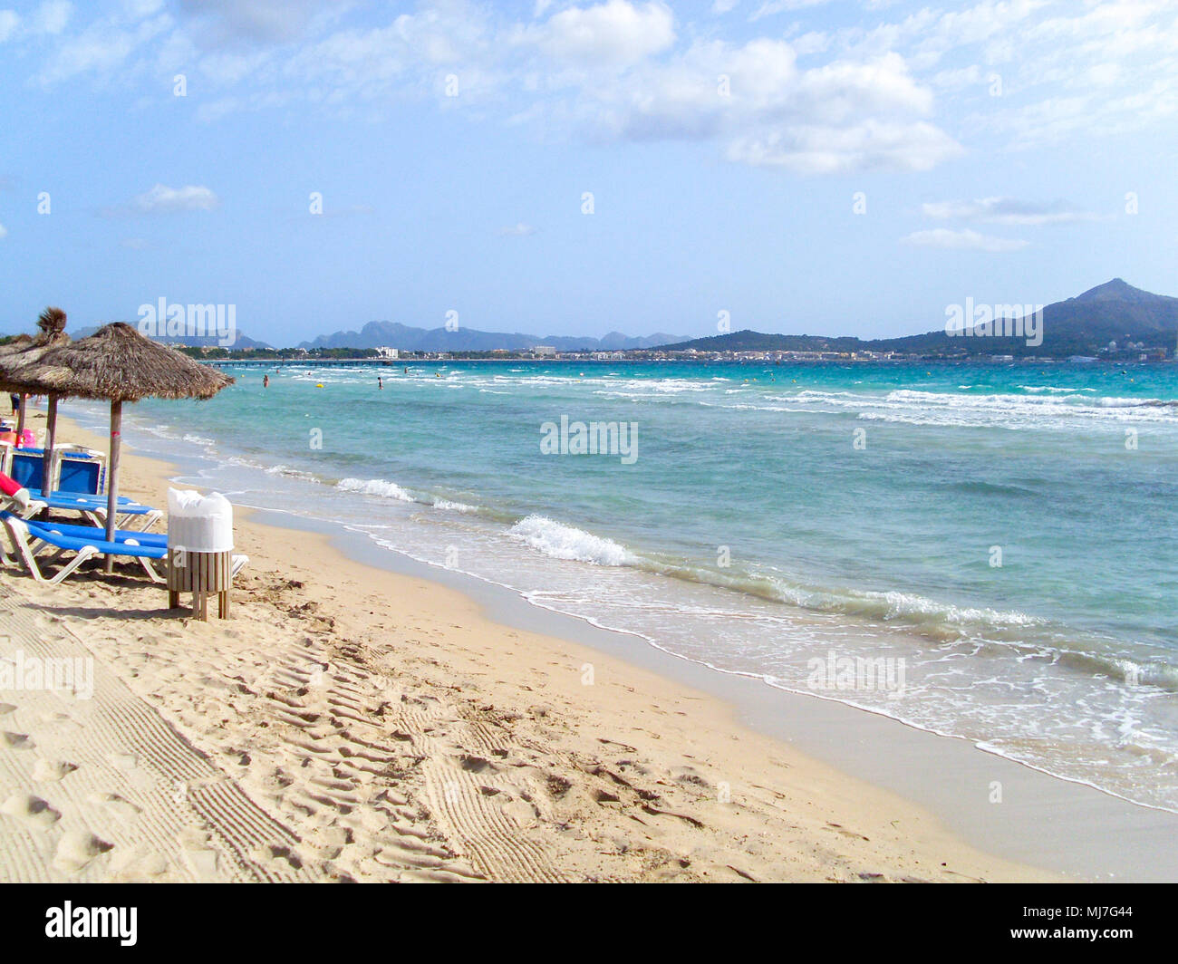 Plage de sable blanc, chaises longues, et l'eau bleue à l'horizon de l'île Banque D'Images