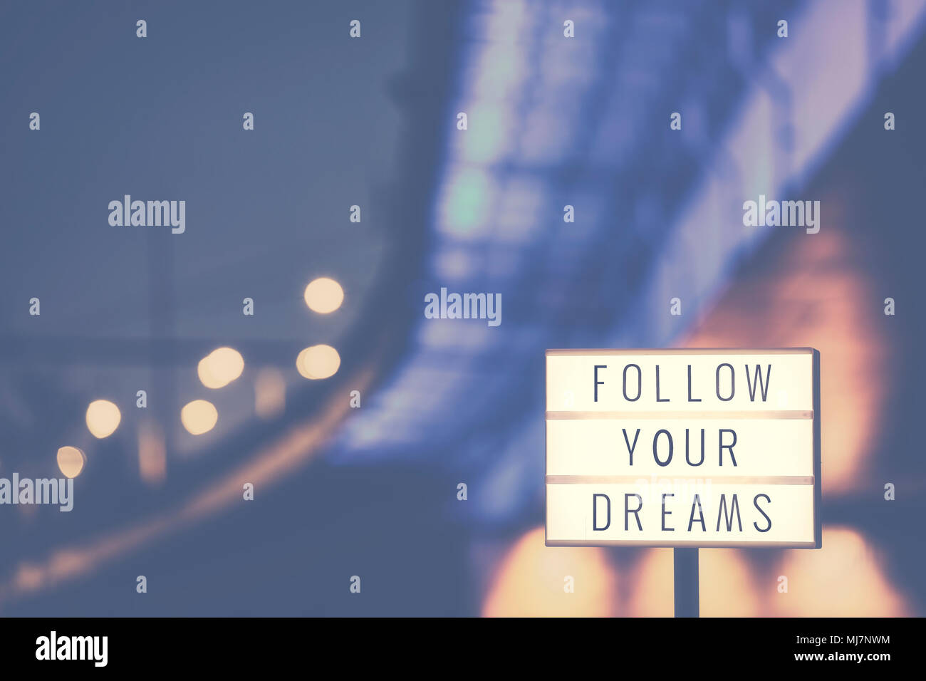 Suivez vos rêves la vie d'inspiration citation texte en sélection, les lumières de la ville en arrière-plan, couleur tonique photo. Banque D'Images