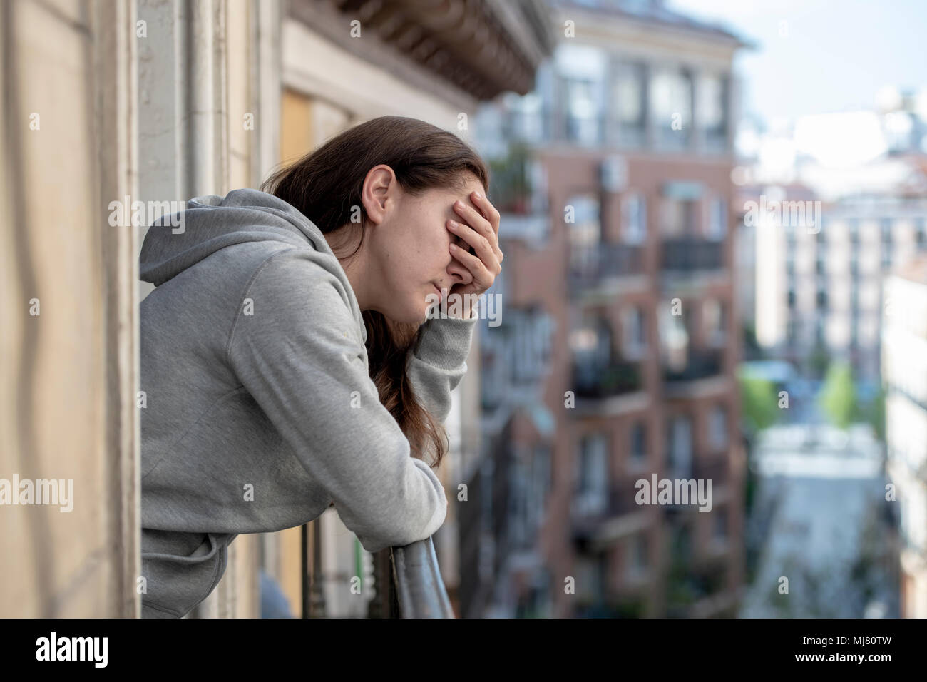 Jeune Latin. triste et déprimé femme debout sur un balcon plus de sentiment accablé et souffrant de dépression en concept de santé mentale Banque D'Images
