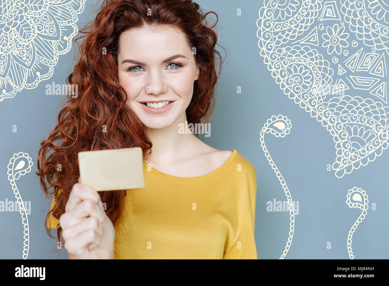 Smiling young woman standing avec une carte de crédit et à la satisfait Banque D'Images