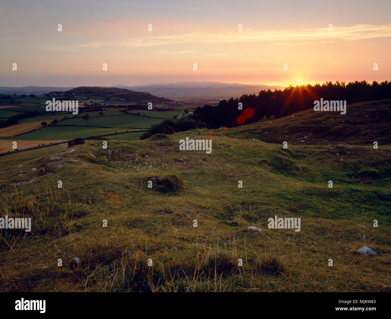 Voir SW au coucher du soleil depuis le sommet de la colline de Gop cairn, Hiraddug vers Moel, fortin avec les montagnes de Snowdonia au loin. Trelawnyd N, Pays de Galles Banque D'Images