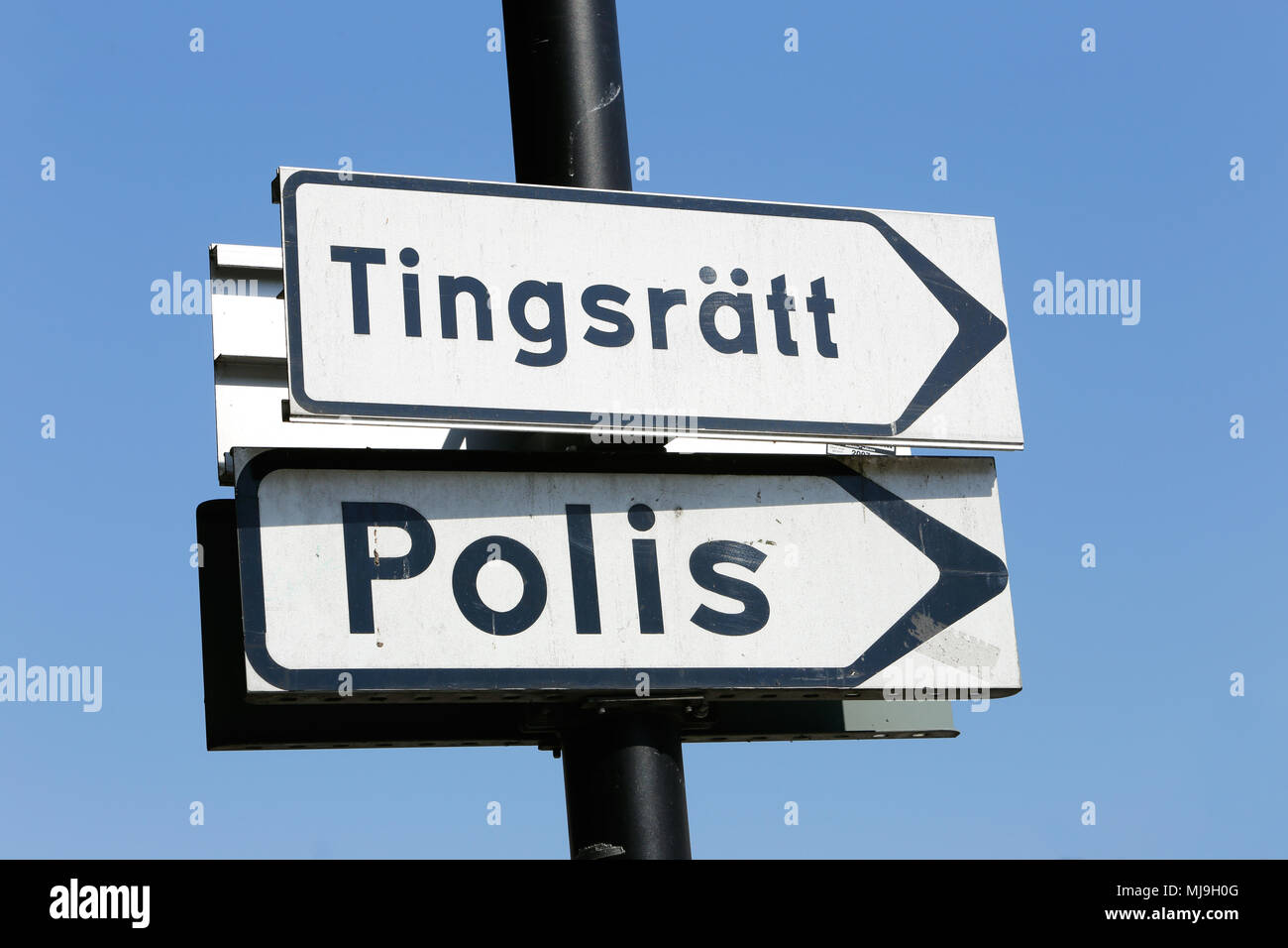Panneau suédois avec des signes orientant vers un poste de police et le tribunal de district. Banque D'Images