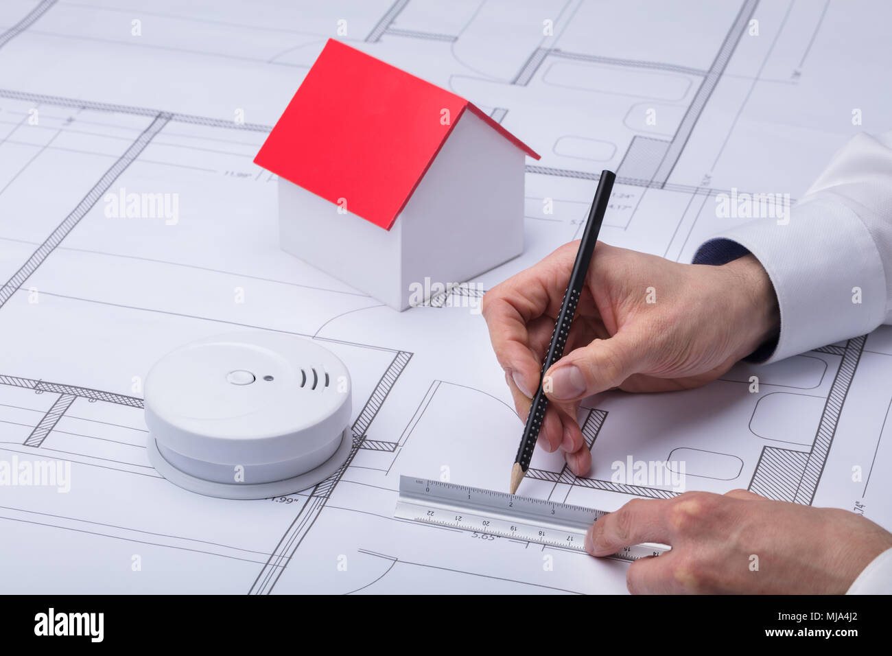Architecture dessin plan près de détecteur de fumée et de modèle de maison Banque D'Images