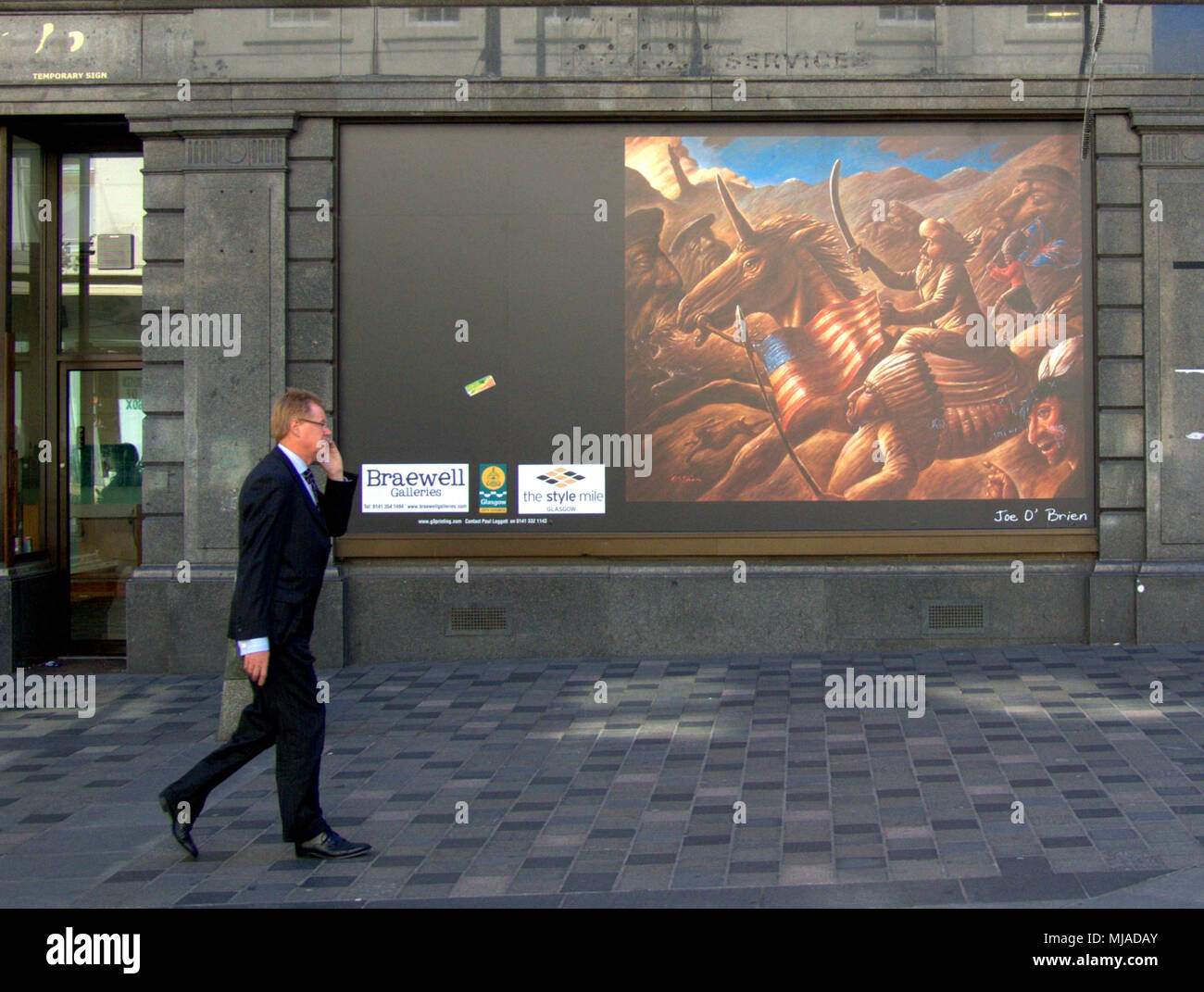 Businessman on mobile phone marche sur Sauchiehall Street en face d'une représentation d'custers last stand, conversation téléphonique références Banque D'Images