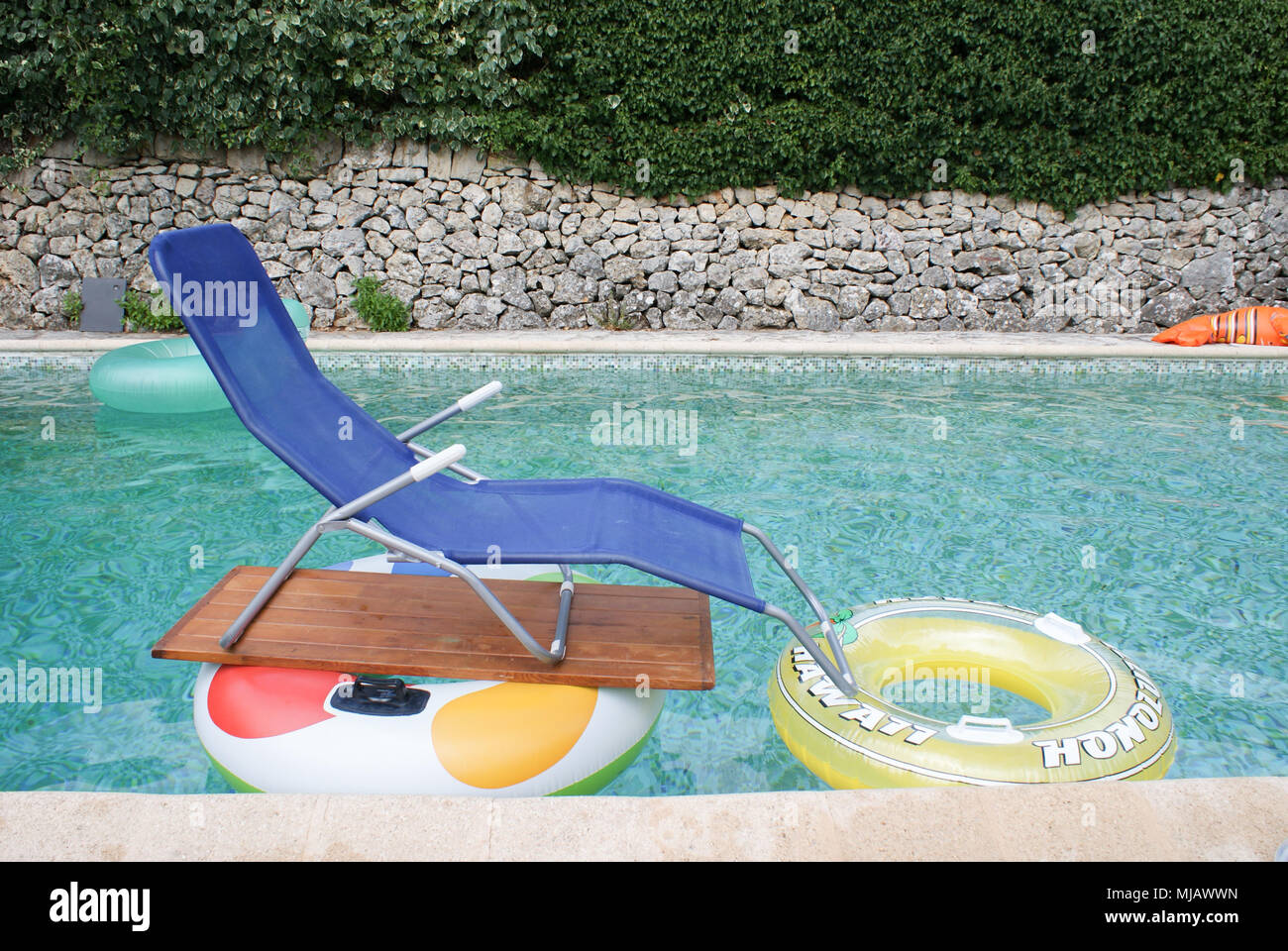 Chaise longue flottante instables dans la piscine Photo Stock - Alamy