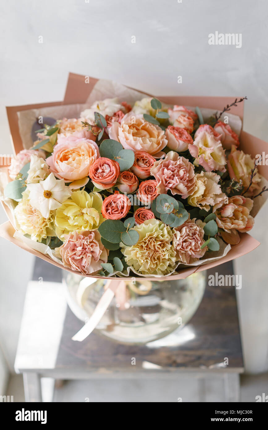 Orange et rose pastel bouquet de belles fleurs sur table en bois. Art  floral concept. Les couleurs du printemps. le travail de la fleuriste à un  magasin de fleur. Photo verticale Photo
