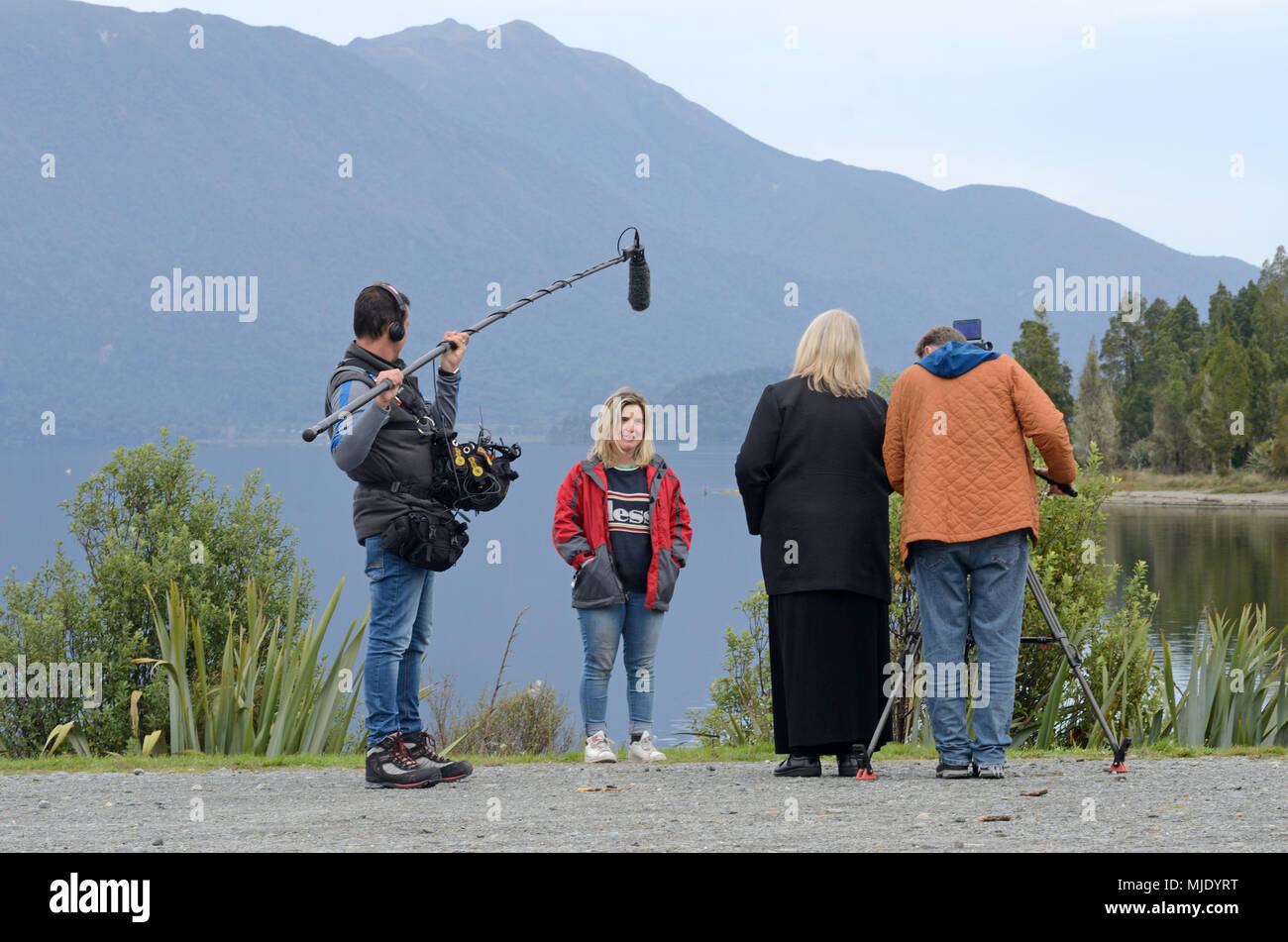 MOANA, Nouvelle-Zélande, le 23 avril 2018 : Une équipe de tournage interviews une jeune femme au bord du lac Brunner pour un documentaire histoire. Banque D'Images