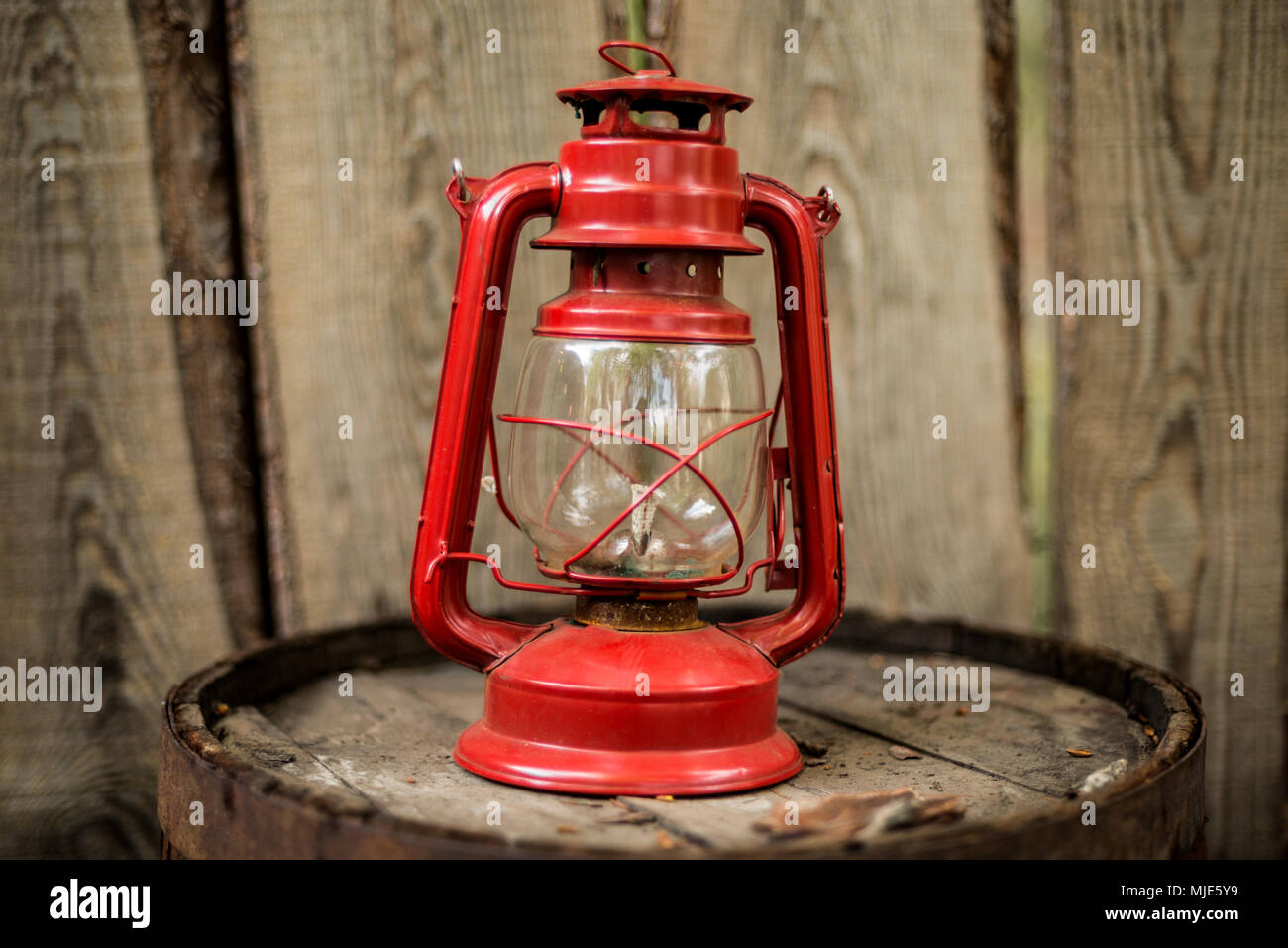 Ancienne rétro style vinatge élément de décoration lampe à huile kérosène rouge sur fond de mur en bois. Banque D'Images