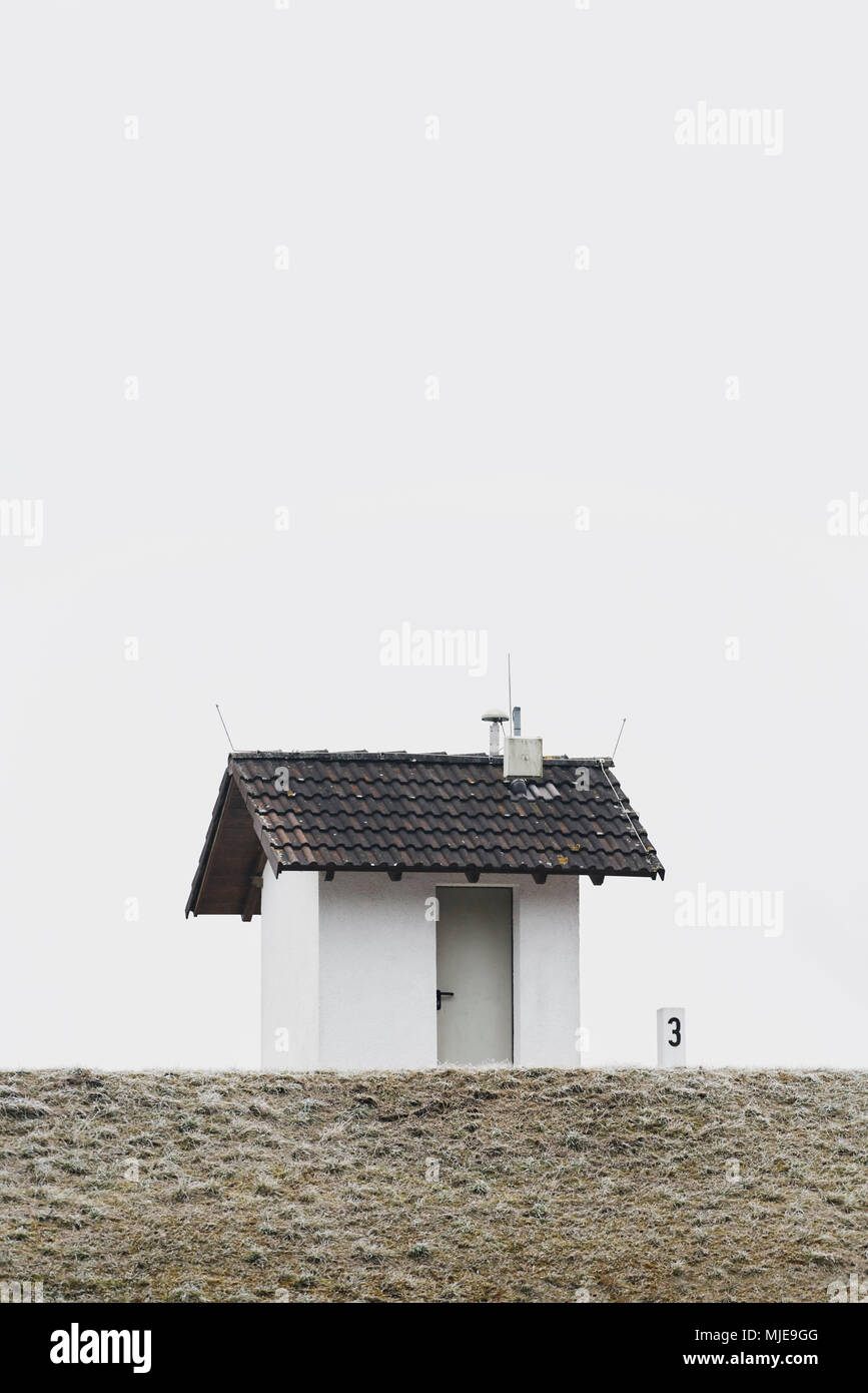 Petite maison sur une digue en hiver, ciel gris blanc, le givre Banque D'Images